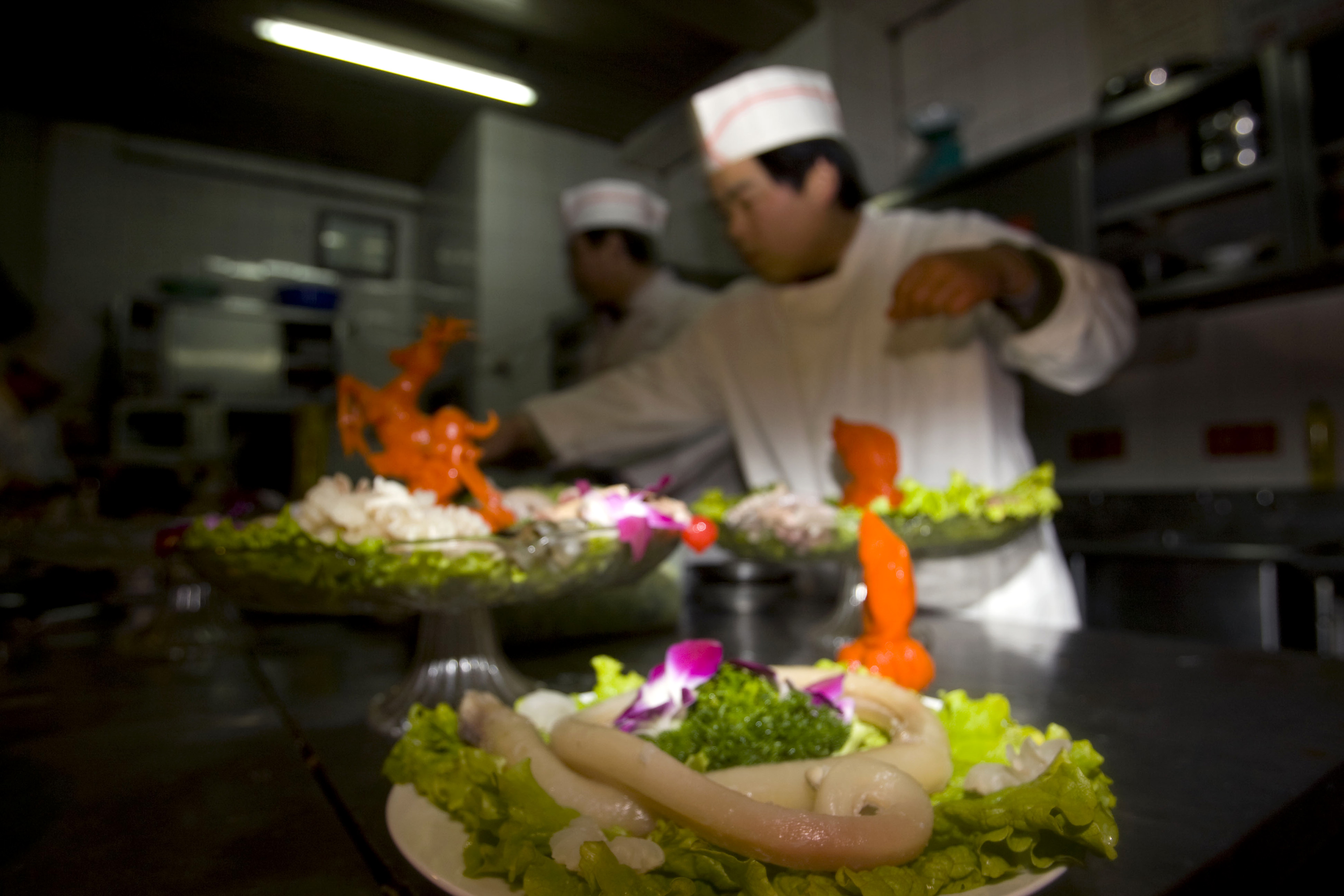 Cooks prepare an ox-penis dish, center, believed to give virility to those who eat it, at a specialty restaurant in Beijing in 2009 (Elizabeth Dalziel—AP)