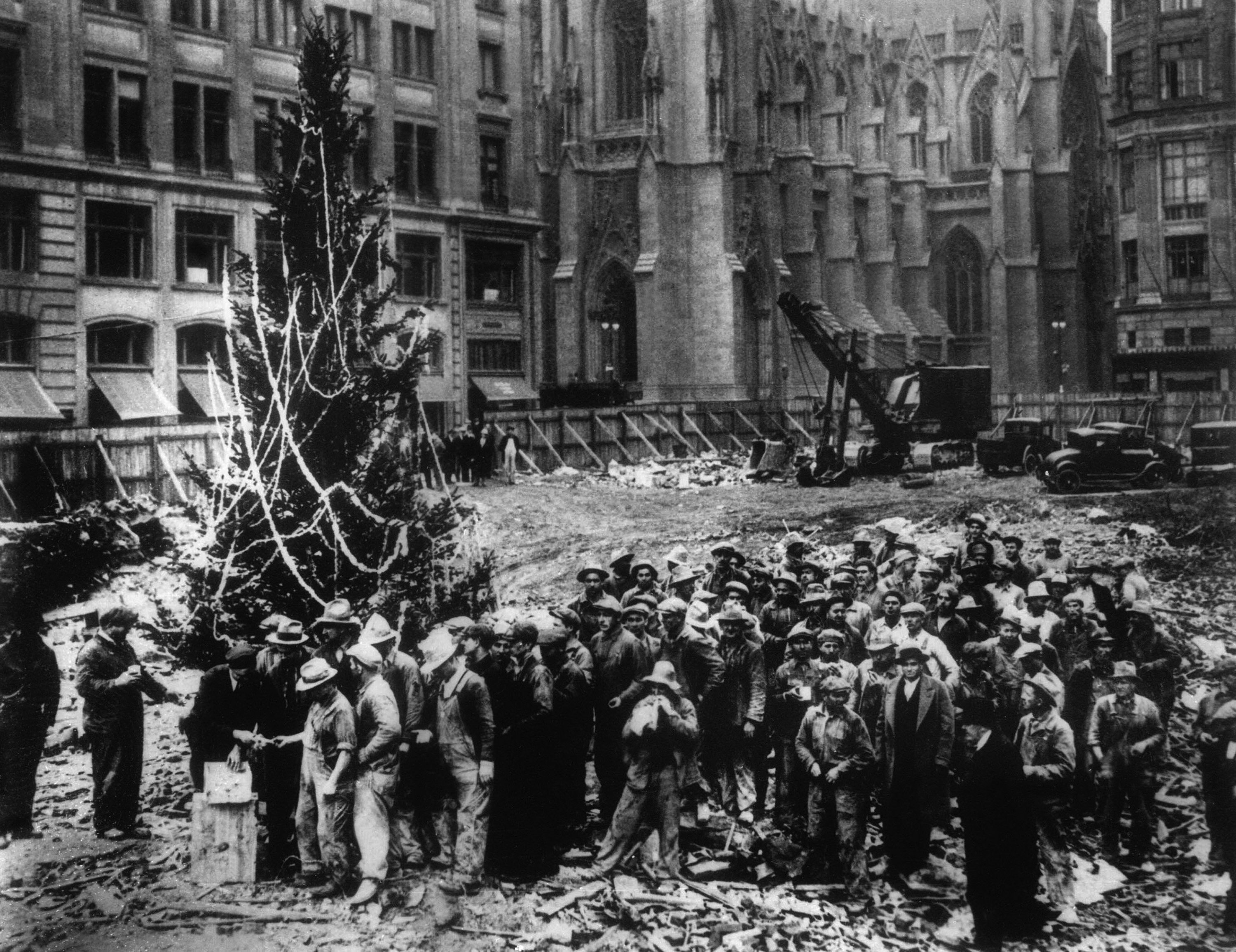 Construction workers line up for pay beside the first Rockefeller Center Christmas tree in New York in 1931. St. Patrick's Cathedral is visible in the background on Fifth Avenue. (AP Photo)