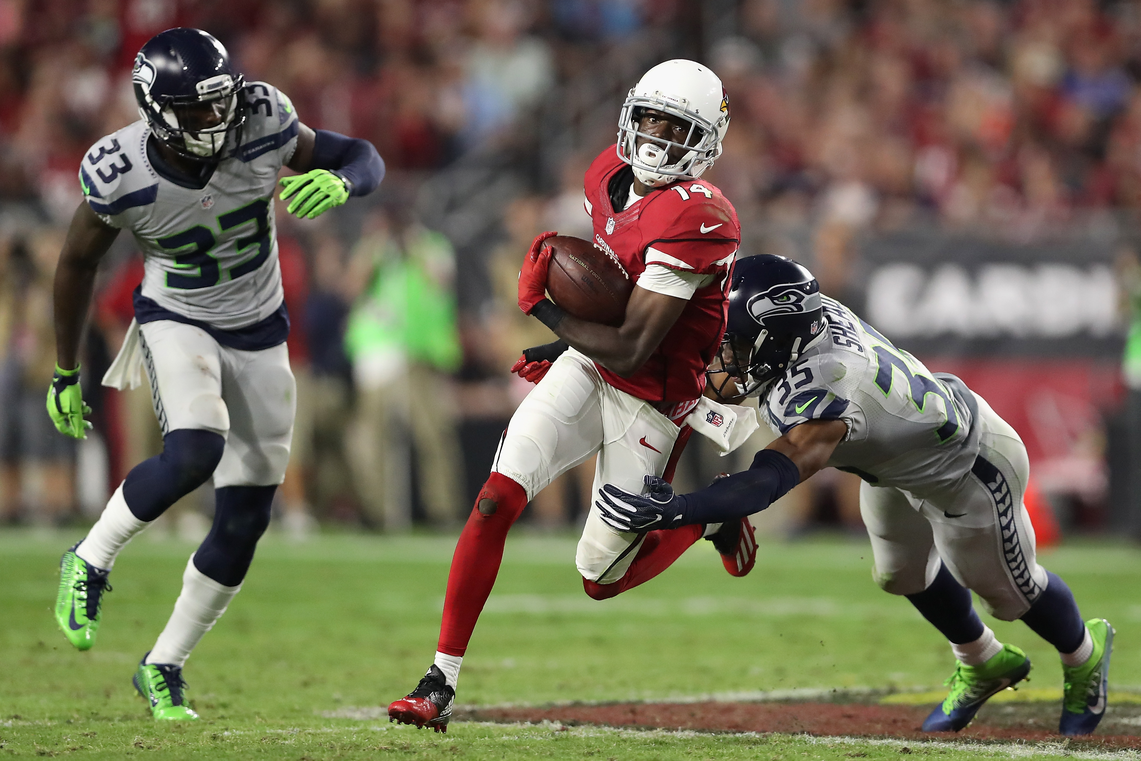 Wide receiver J.J. Nelson #14 of the Arizona Cardinals runs with the football after a reception past cornerback DeShawn Shead #35 of the Seattle Seahawks during the NFL game at the University of Phoenix Stadium on Oct. 23. (Christian Petersen—Getty Images)