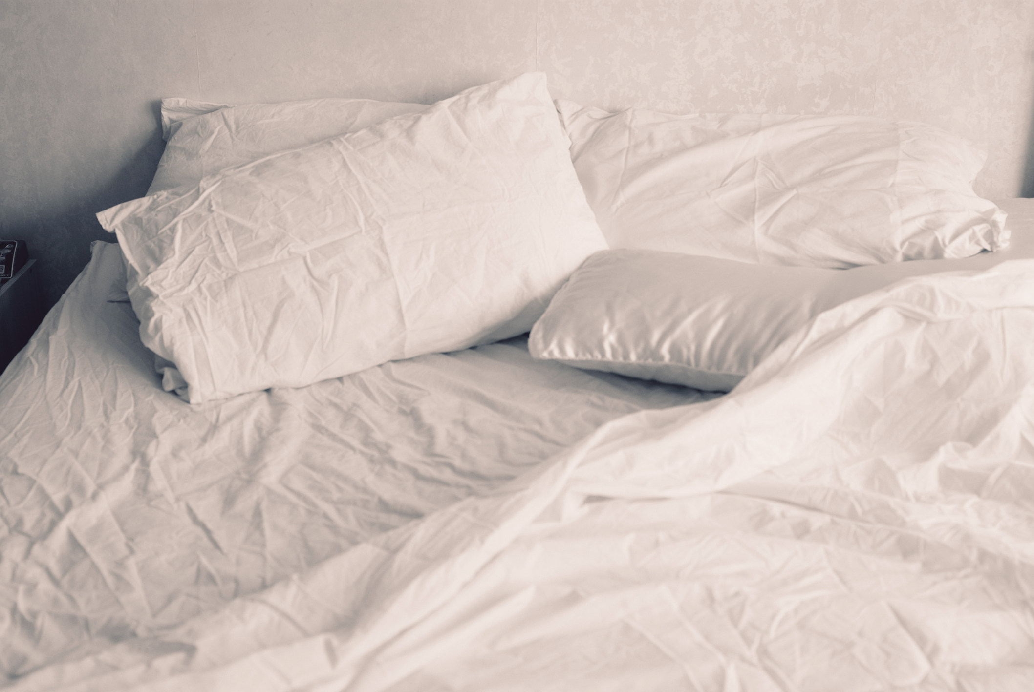 White linen of an unmade bed, empty