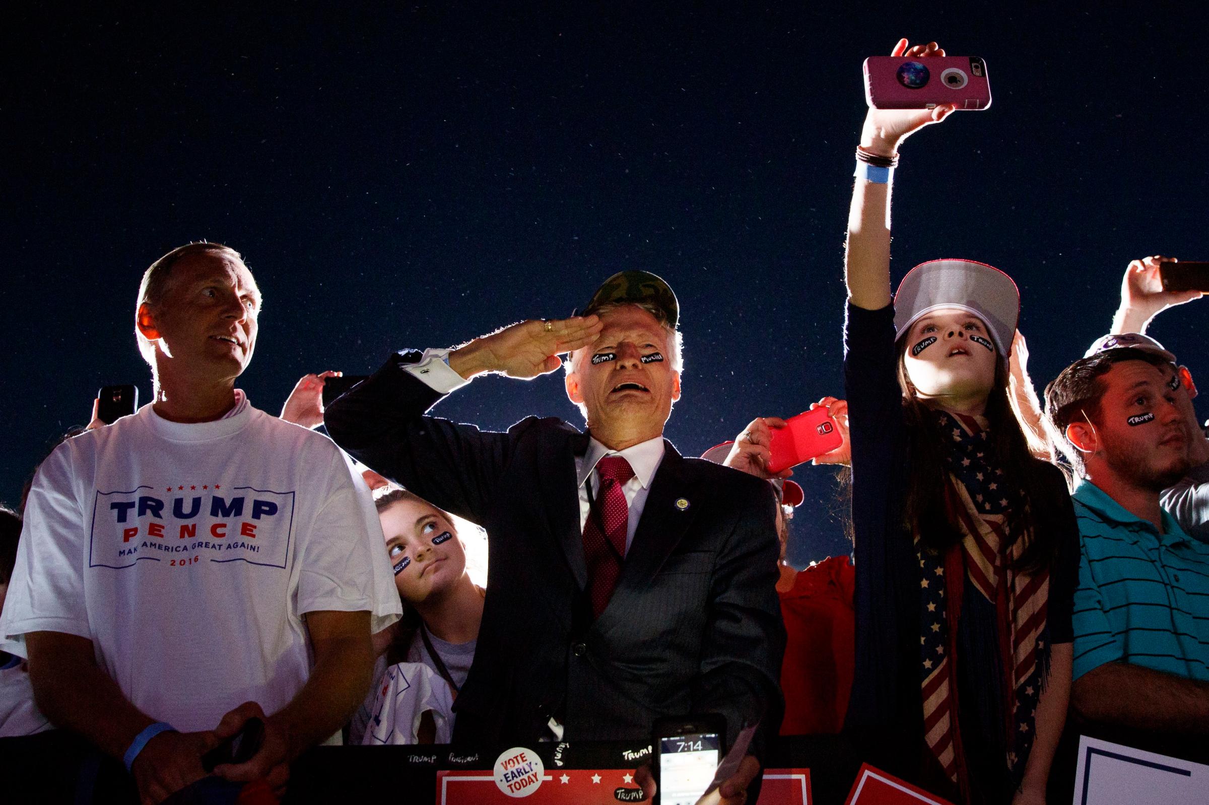 Jeff Muller of Wilmington, N.C., salutes as Donald Trump arrives at a campaign rally in Kinston, N.C., on Oct. 26, 2016.