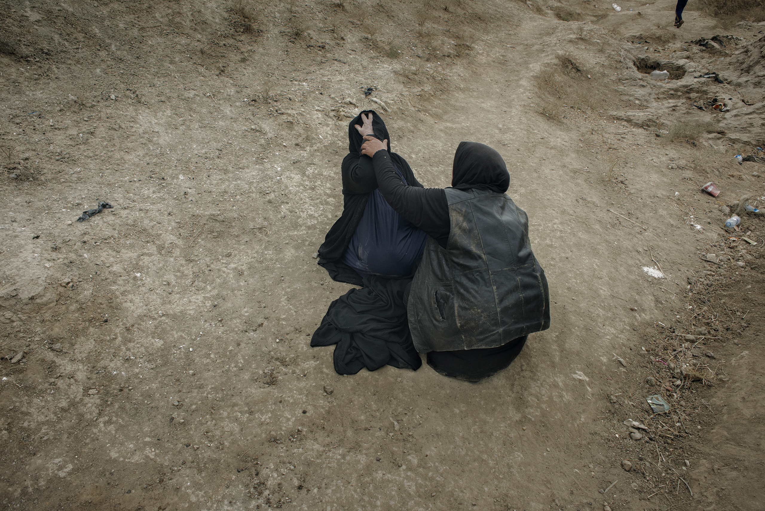 A woman comforts another woman whose son was taken by ISIS as they tried to cross the Tigris River in northern Iraq.