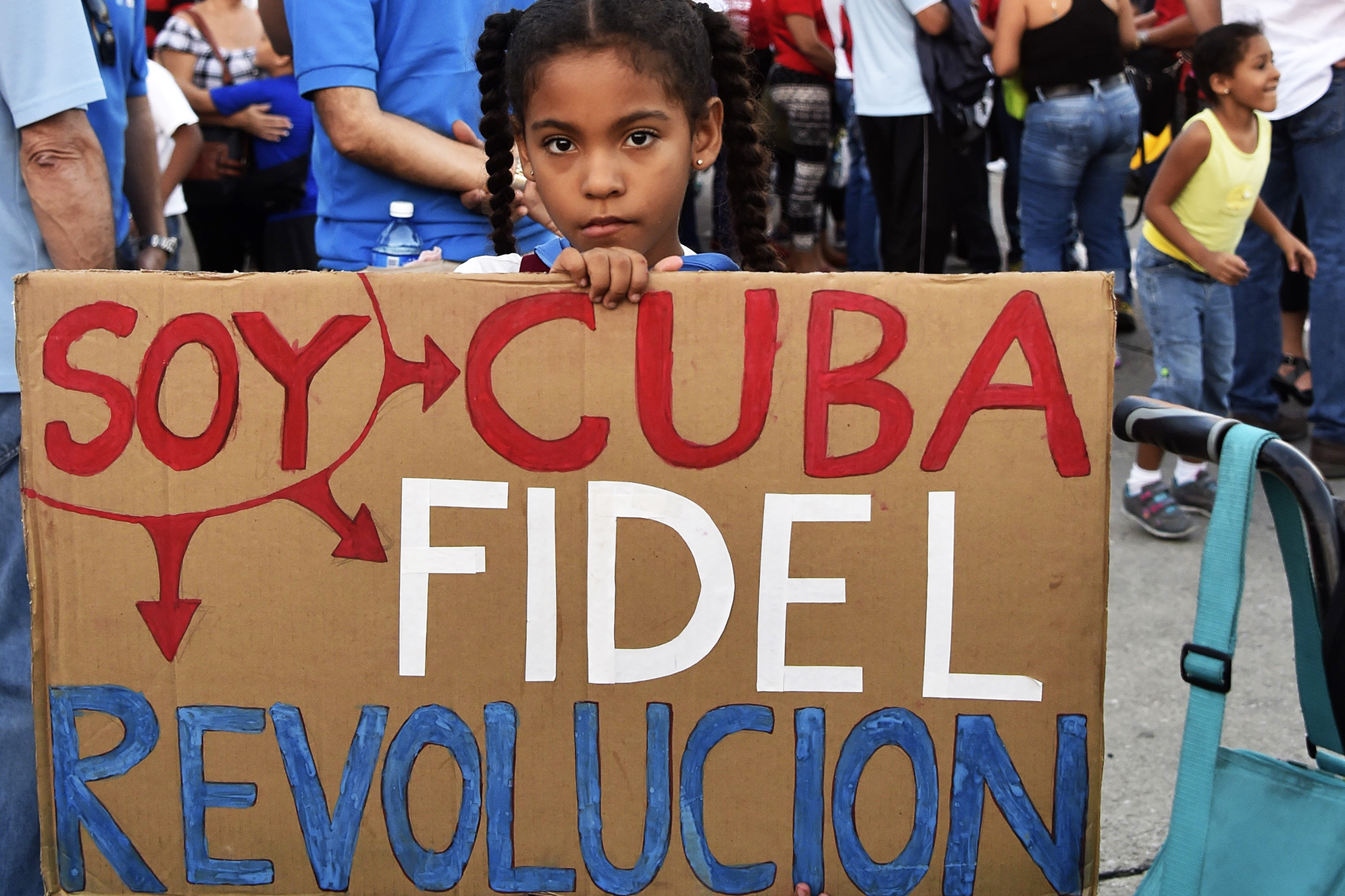 A girl holds a sign reading "I am Cuba, Fidel, Revolution" as Cubans gather at Revolution Square to pay homage to Fidel Castro in Havana, on Nov. 29, 2016.