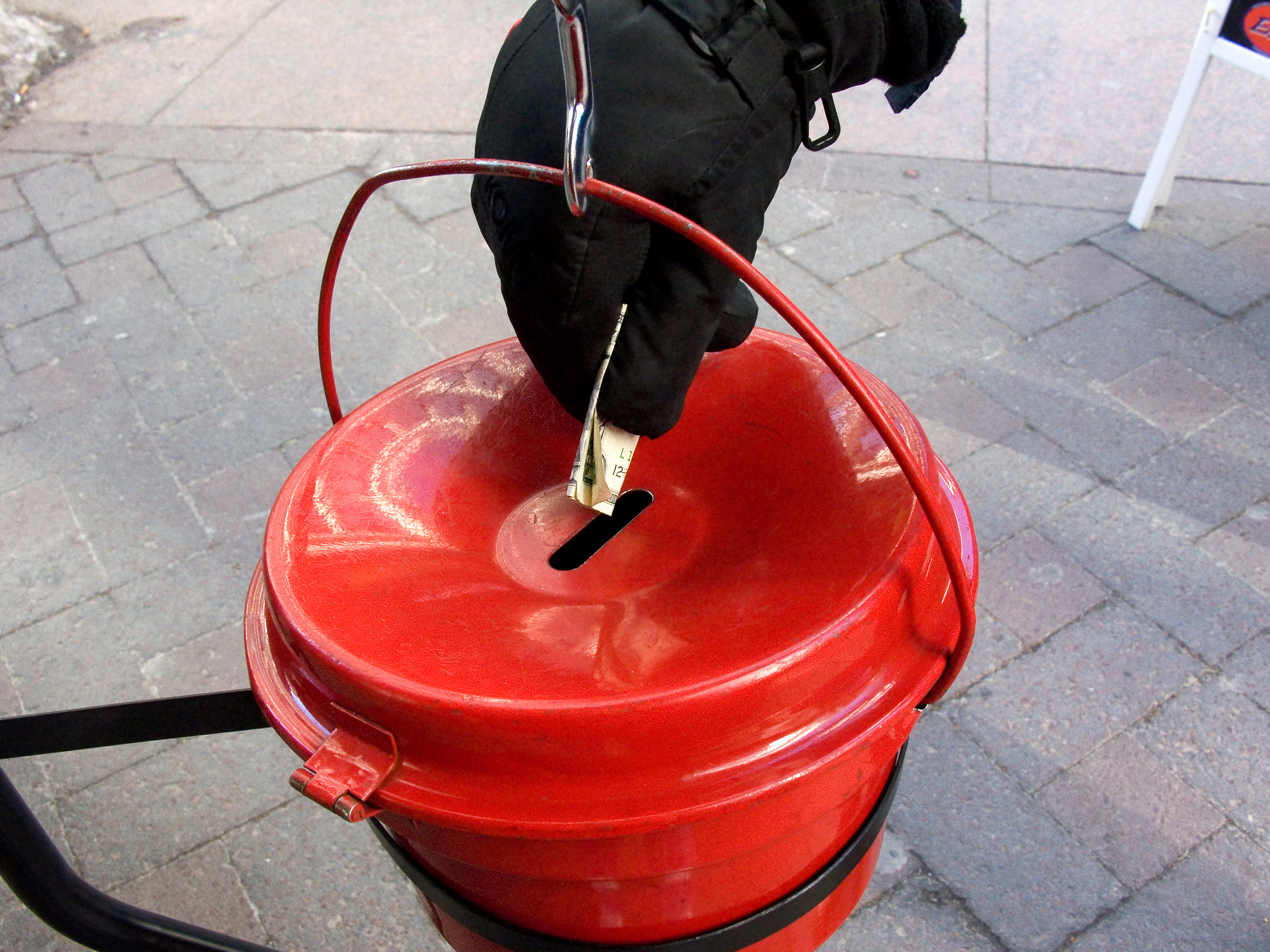 Person putting money into a Salvation Army kettle. (Eunice Harris&mdash;Getty Images/Science Source)