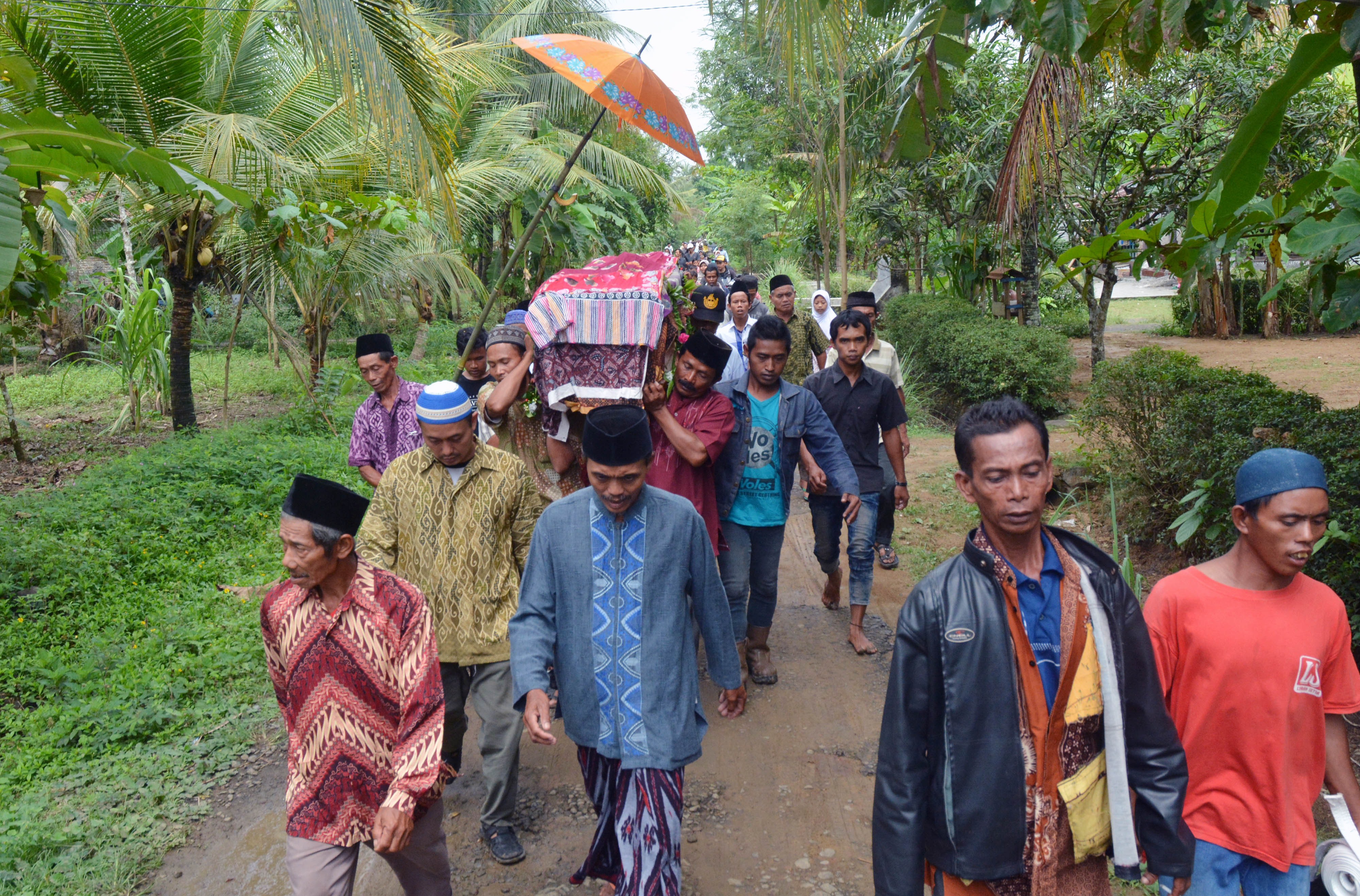 Relatives and villagers carry the coffin of Sumarti Ningsih, one of two Indonesian women murdered by British banker Rurik Jutting in Hong Kong, during her funeral at Gandrungmangu village, in Cilacap, Indonesia's Central Java province, on Nov. 12, 2014 (Dida Nuswantara—AFP/Getty Images)