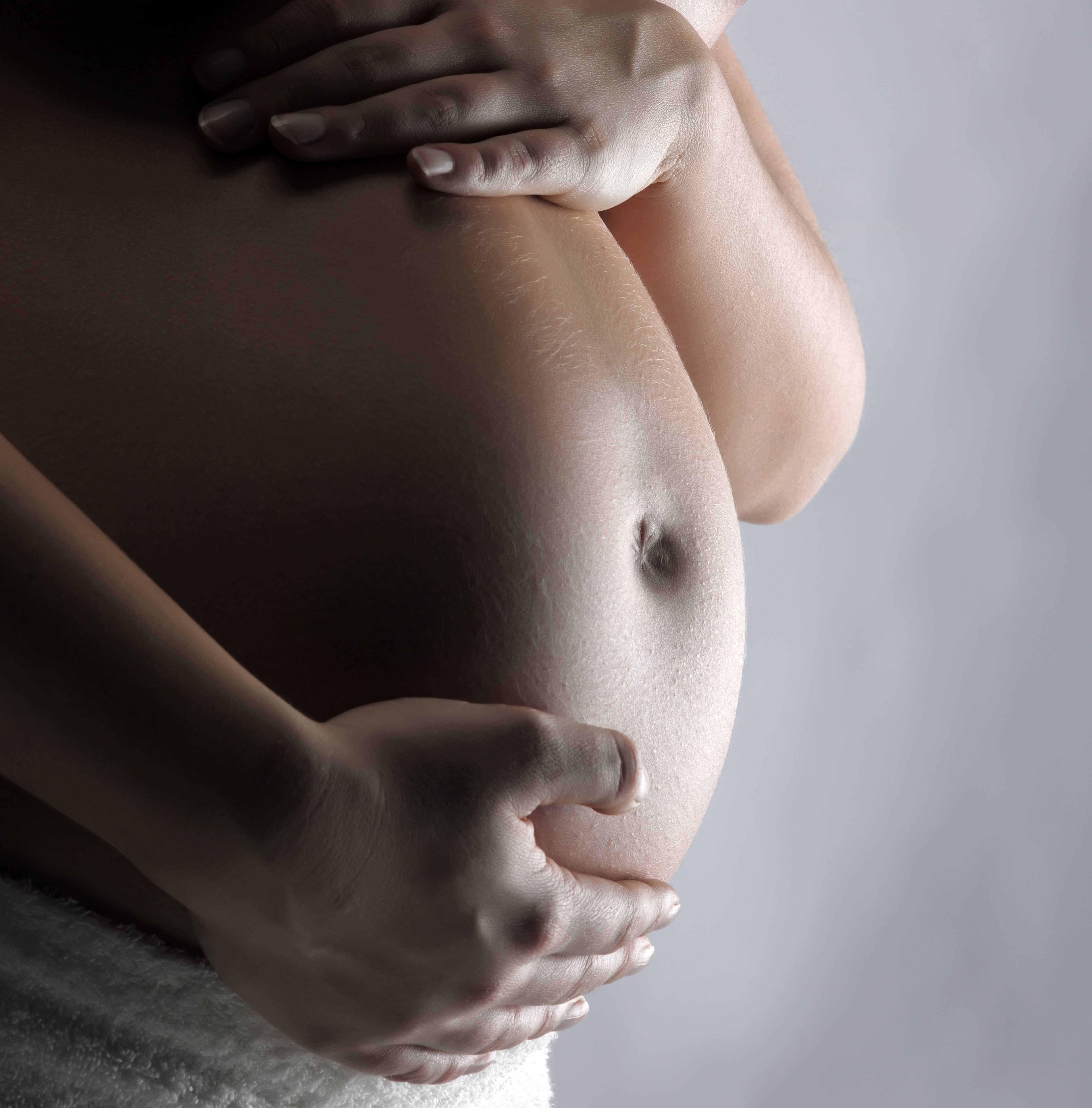 Pregnant woman supporting tummy