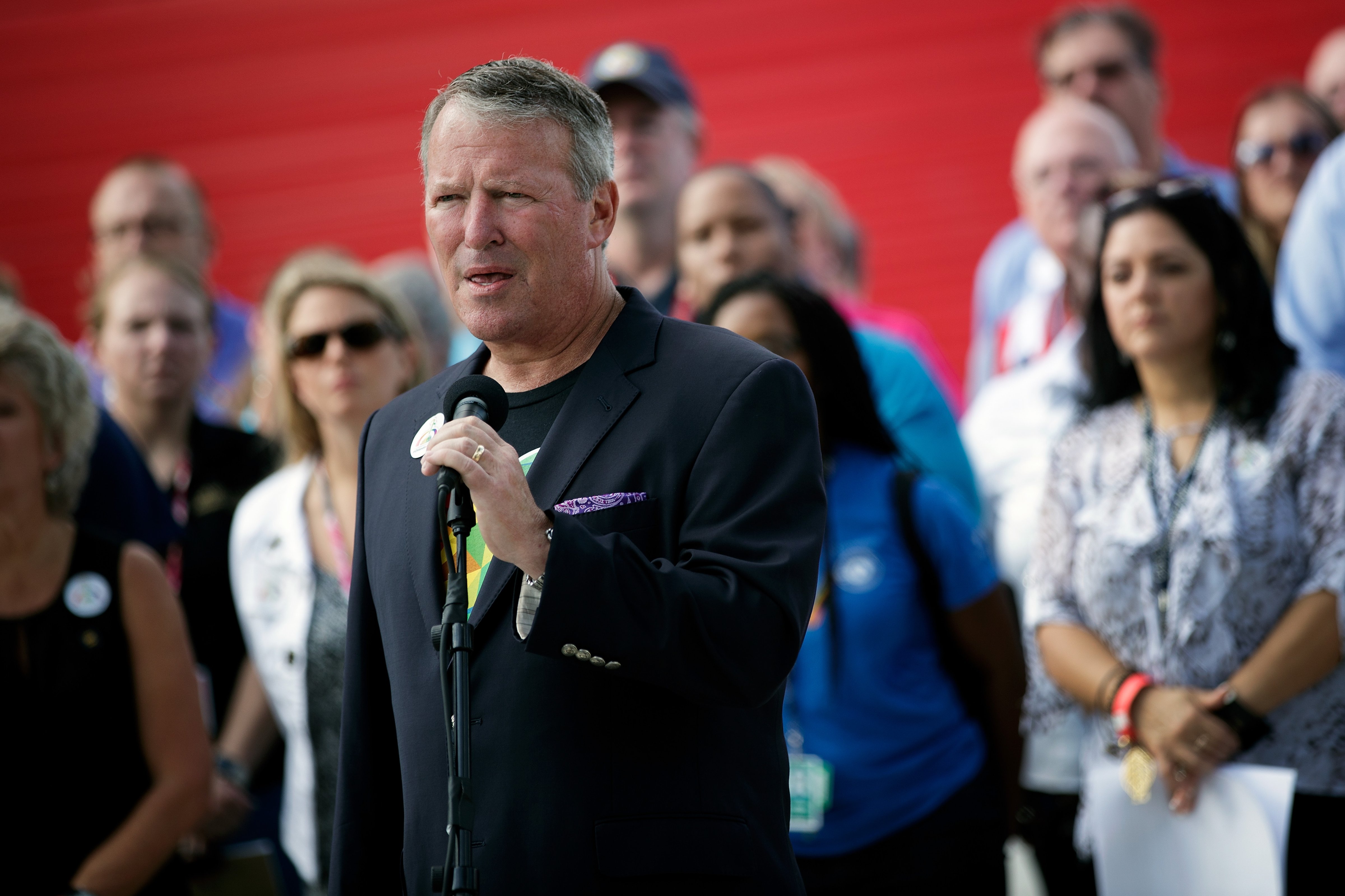 Surrounded by members of federal, state and local agencies, Orlando Mayor Buddy Dyer speaks at a press conference to provide an update on the assistance being provided to victims' families at the Orland Family Assistance Center, at Camping World Stadium, June 17, 2016 in Orlando, Florida. (Drew Angerer—Getty Images)