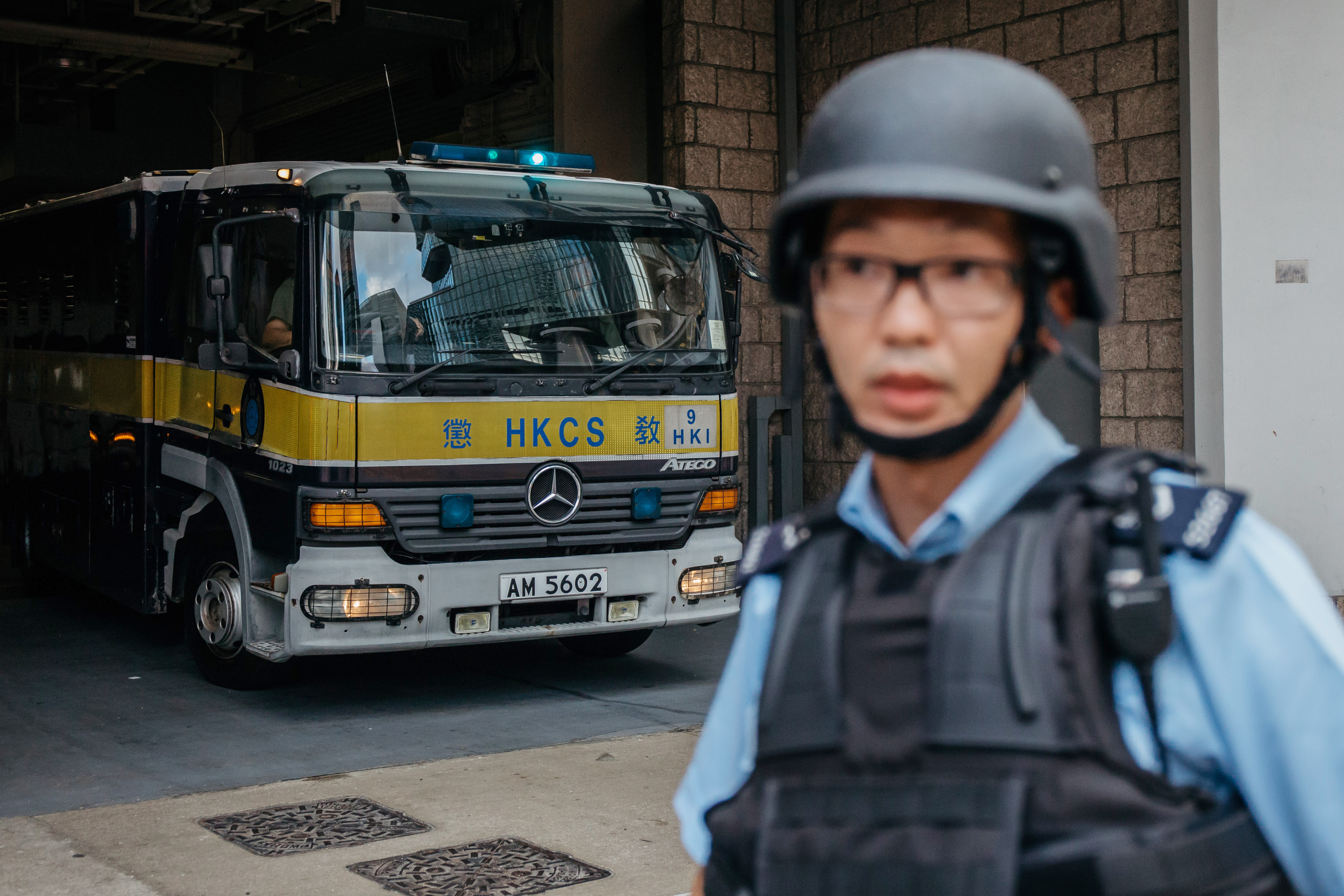 A police officer stands guard as a prison vehicle escorting Rurik Jutting, a former Bank of America Merrill Lynch employee, leaves the High Court in Hong Kong on Oct. 24, 2016 (Bloomberg/Getty Images)