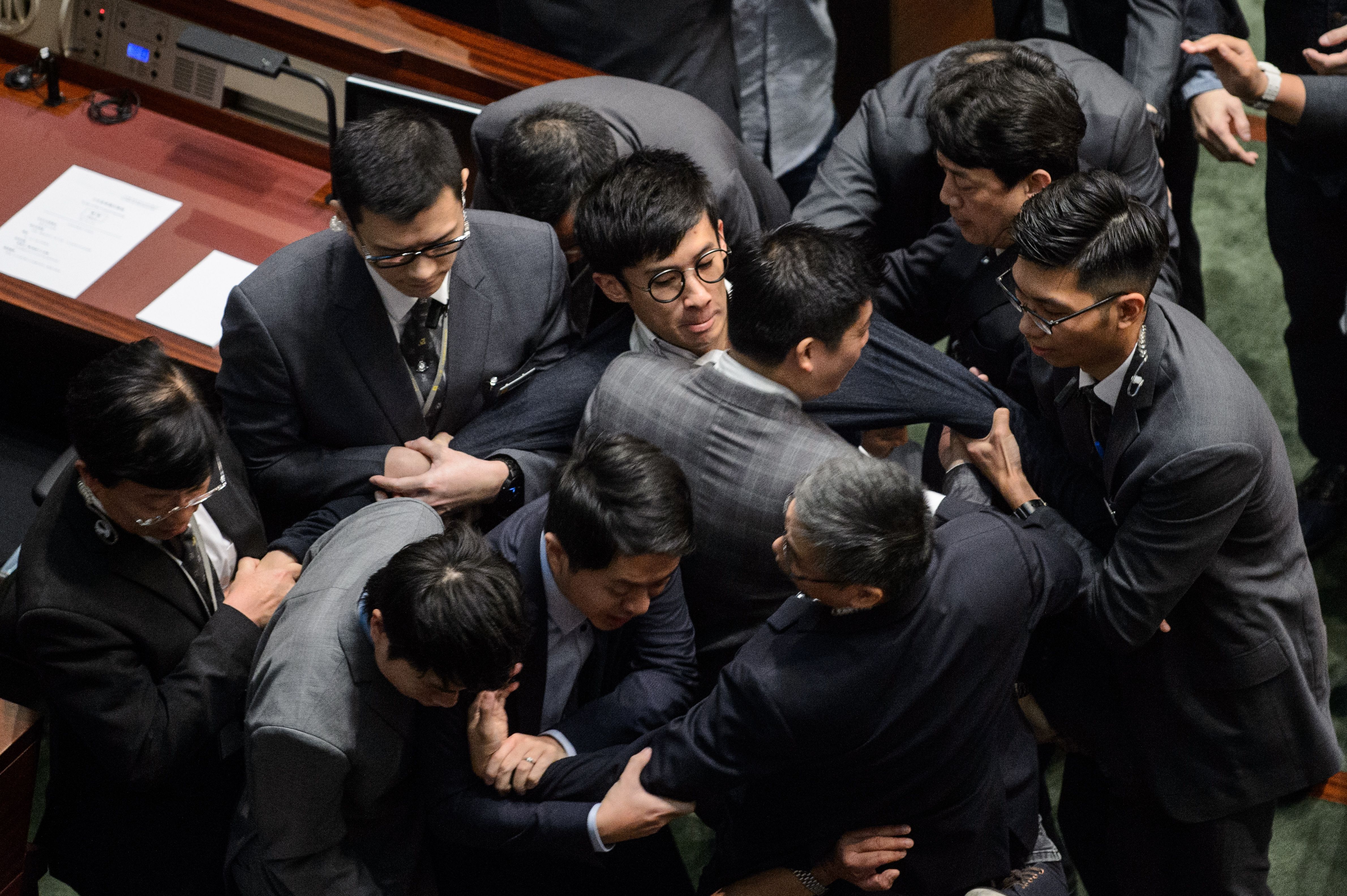Newly elected lawmaker Baggio Leung is restrained by security after attempting to read out his Legislative Council oath at Legislative Council in Hong Kong on Nov. 2, 2016 (Anthony Wallace—AFP/Getty Images)