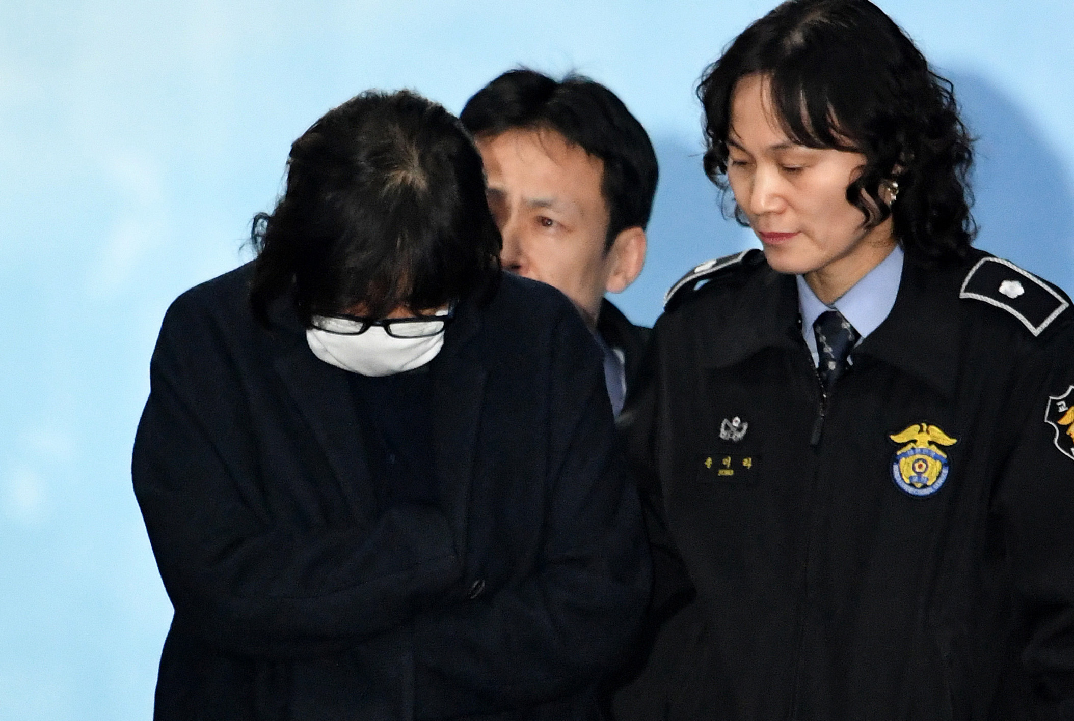 Choi Soon-Sil, front left, the woman at the heart of a lurid political scandal engulfing South Korea's President Park Geun-hye, is escorted following her formal arrest, from the Central District Court in Seoul on Nov. 3, 2016 (AFP/Getty Images)