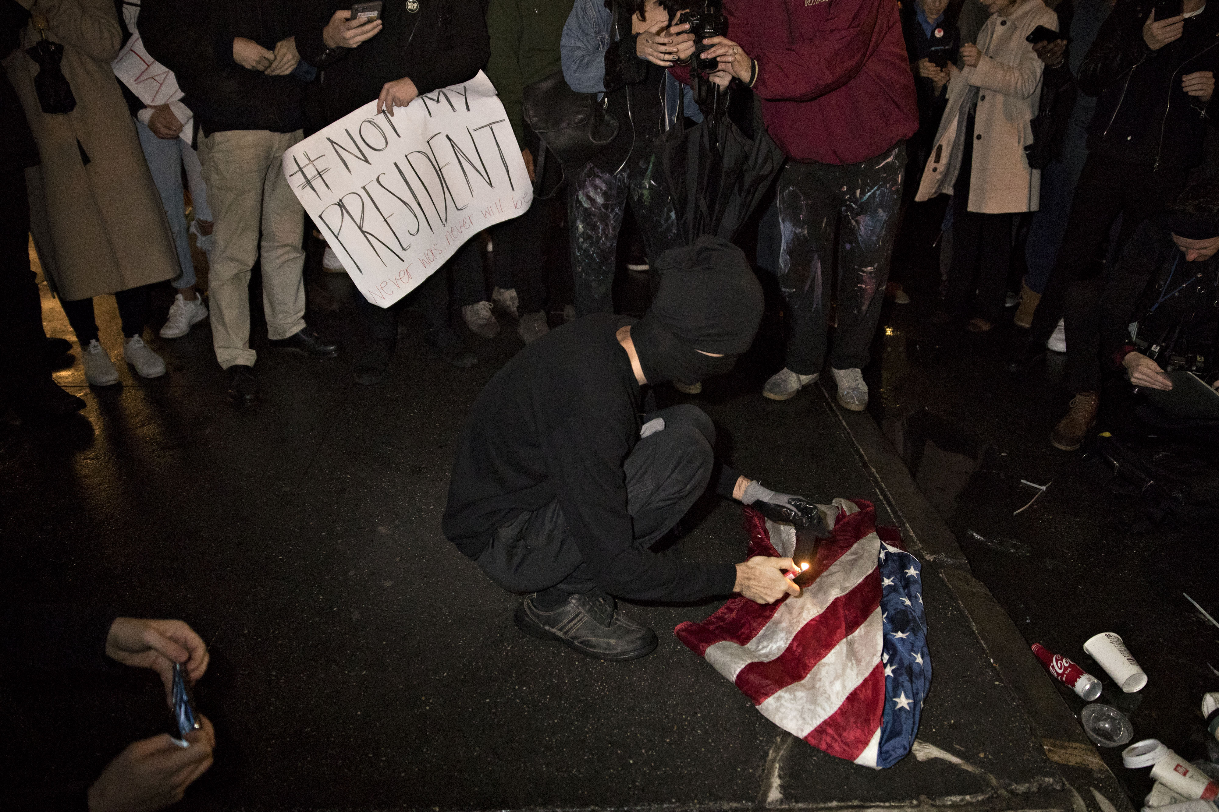 A demonstrator lights an American flag on fire during a rally against U.S. President-elect Donald Trump near Trump Tower in New York, U.S., on Wednesday, Nov. 9, 2016. (Andrew Harrer—Bloomberg/Getty Images)