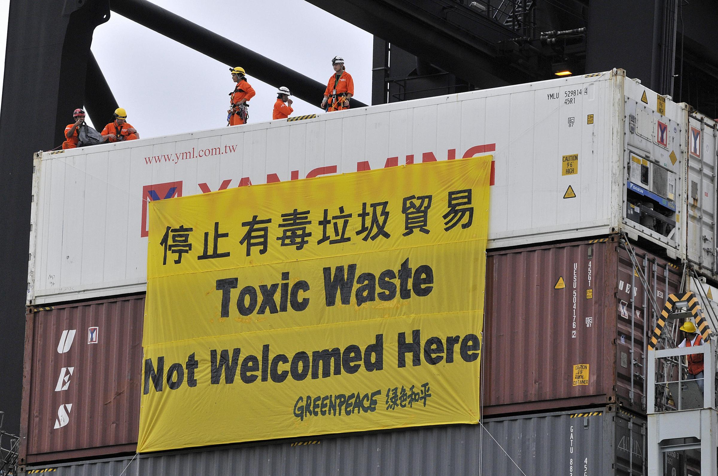 Greenpeace activists lower a banner on a