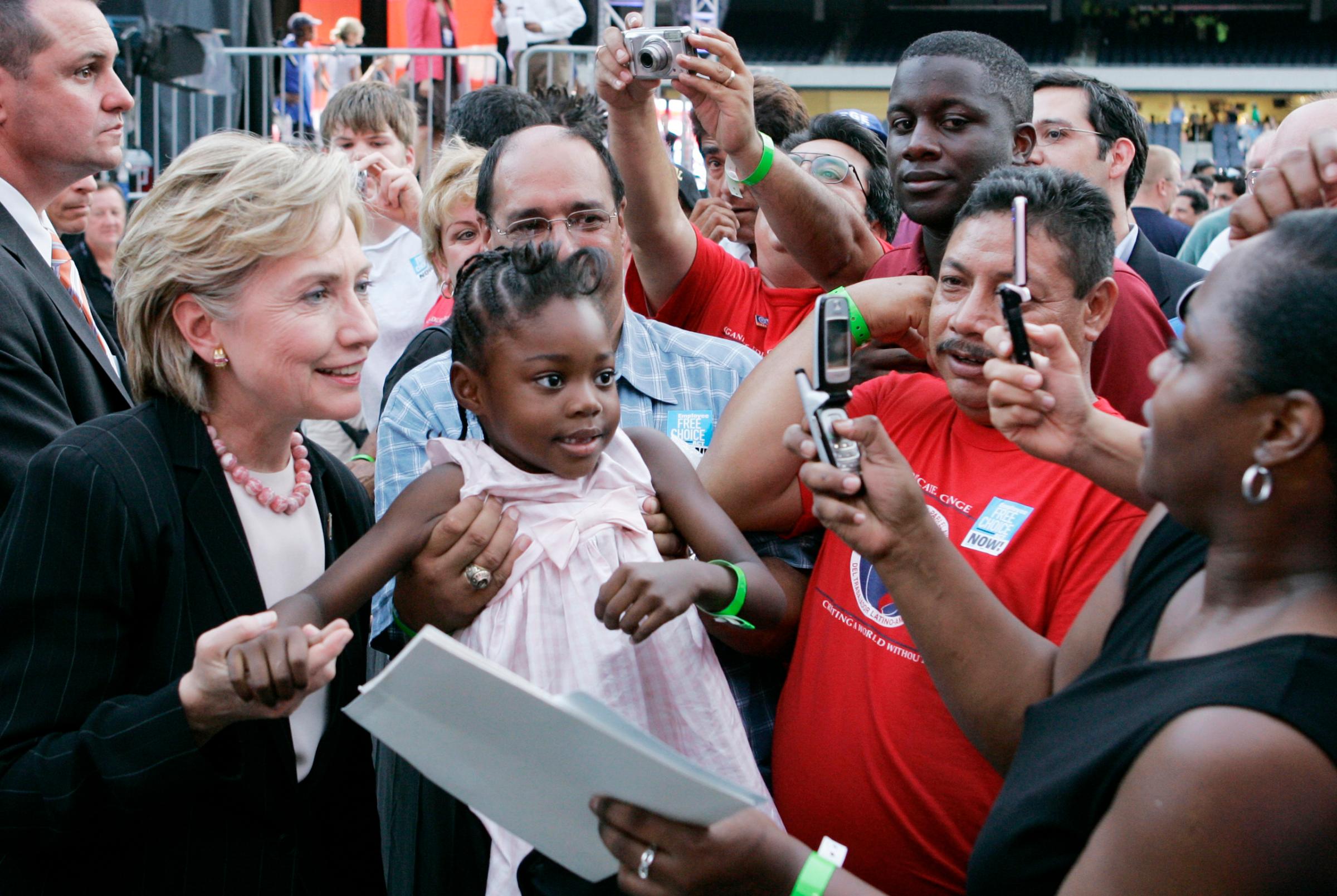 Hillary Clinton poses with a young girl after a presidential forum hosted by the AFL-CIO at Soldier Field in Chicago, on Aug. 7, 2007.