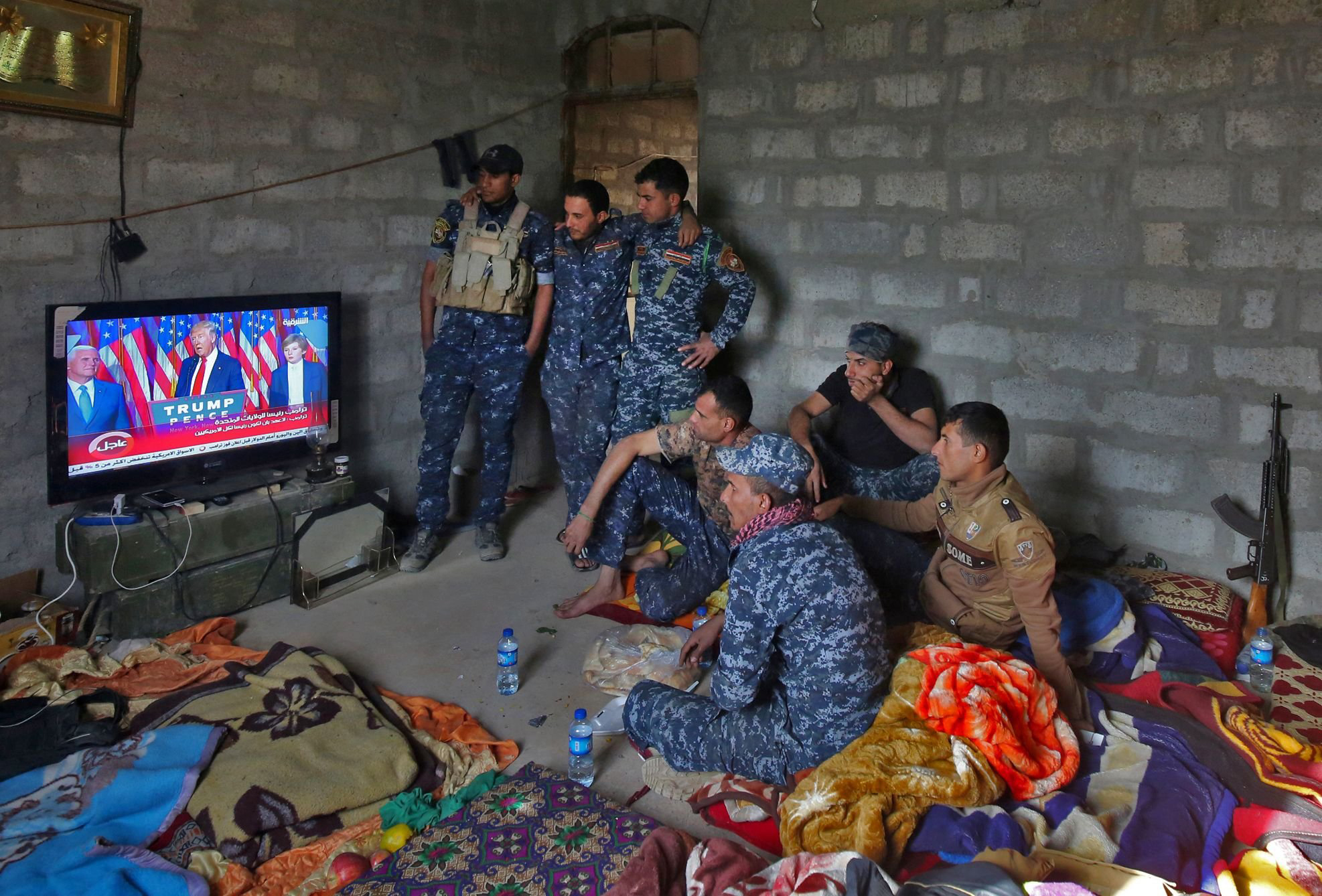 Members of the Iraqi forces watch President-elect Donald Trump give a speech after he won the U.S. presidential elections on a TV set while resting in the village of Arbid, on the southern outskirts of Mosul, on Nov. 9, 2016. (Ahmad al-Rubaye—AFP/Getty Images)