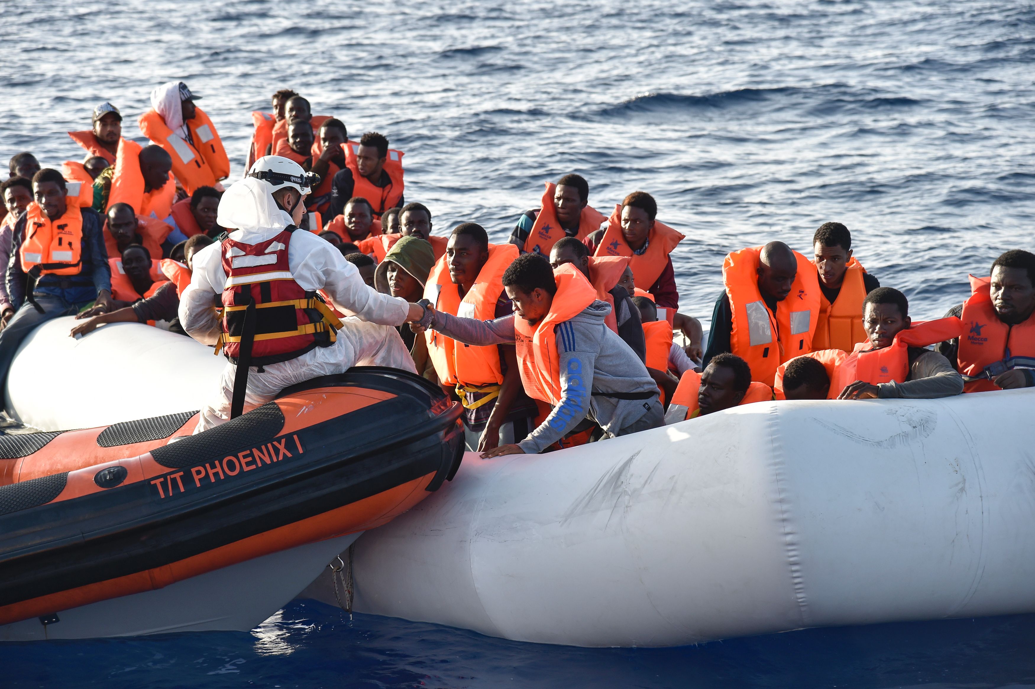 Members of Maltese NGO MOAS help people to board a small rescue boat during a rescue operation of migrants and refugees by the Topaz Responder ship run by Maltese NGO Moas and the Italian Red Cross, on Nov. 3, 2016, off the Libyan coast in the Mediterranean Sea. (Andreas Solaro—AFP/Getty Images)