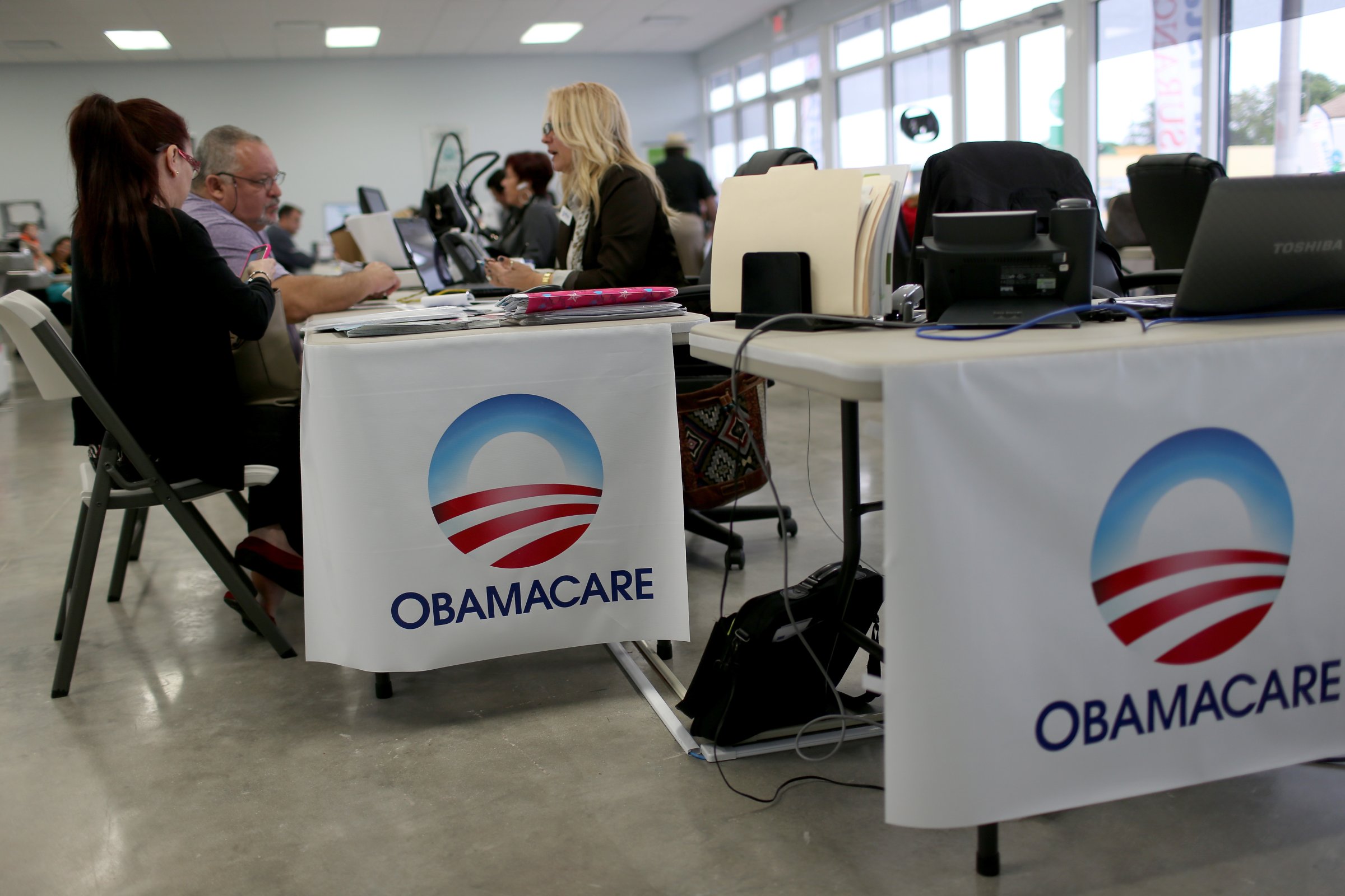 Aymara Marchante (L) and Wiktor Garcia sit with Maria Elena Santa Coloma, an insurance advisor with UniVista Insurance company, as they sign up for the Affordable Care Act, also known as Obamacare, before the February 15th deadline on February 5, 2015 in Miami, Florida.