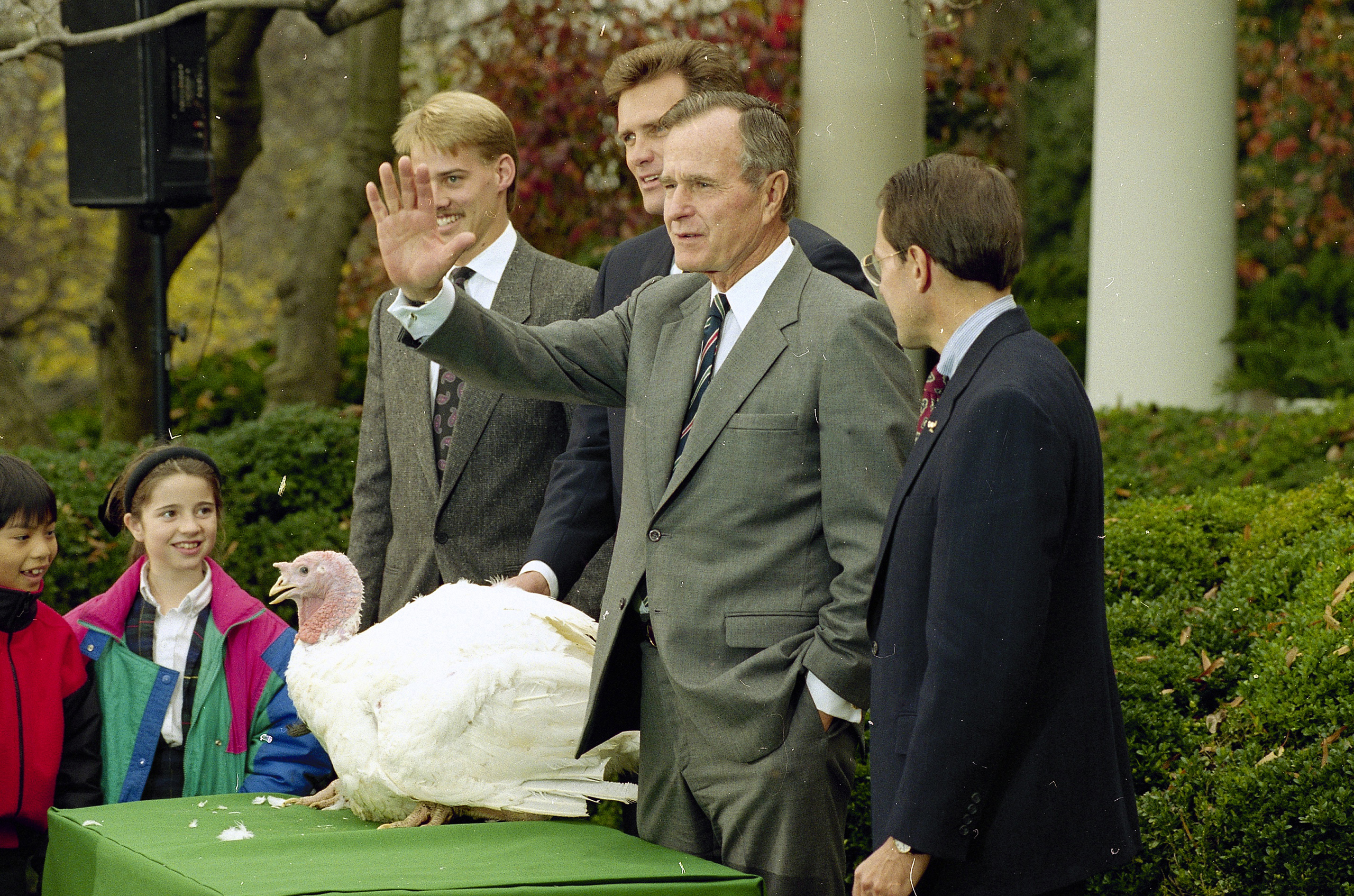 President George H.W. Bush gestures during a Rose Garden ceremony where he pardoned the Thanksgiving turkey presented by the National Turkey Federation, on Nov. 25, 1992.