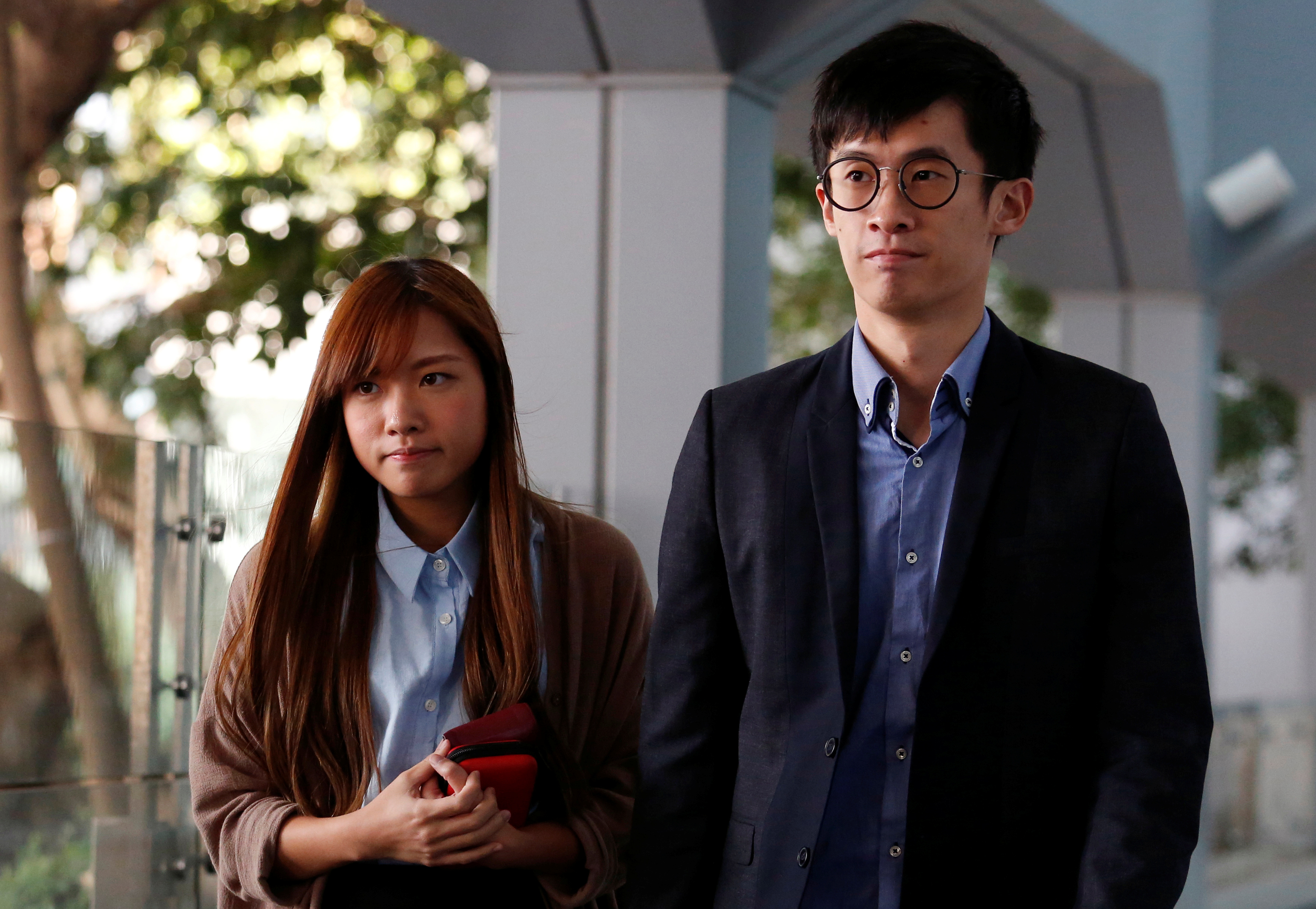 Pro-independence legislator-elects Baggio Leung and Yau Wai-ching walk to the High Court in Hong Kong