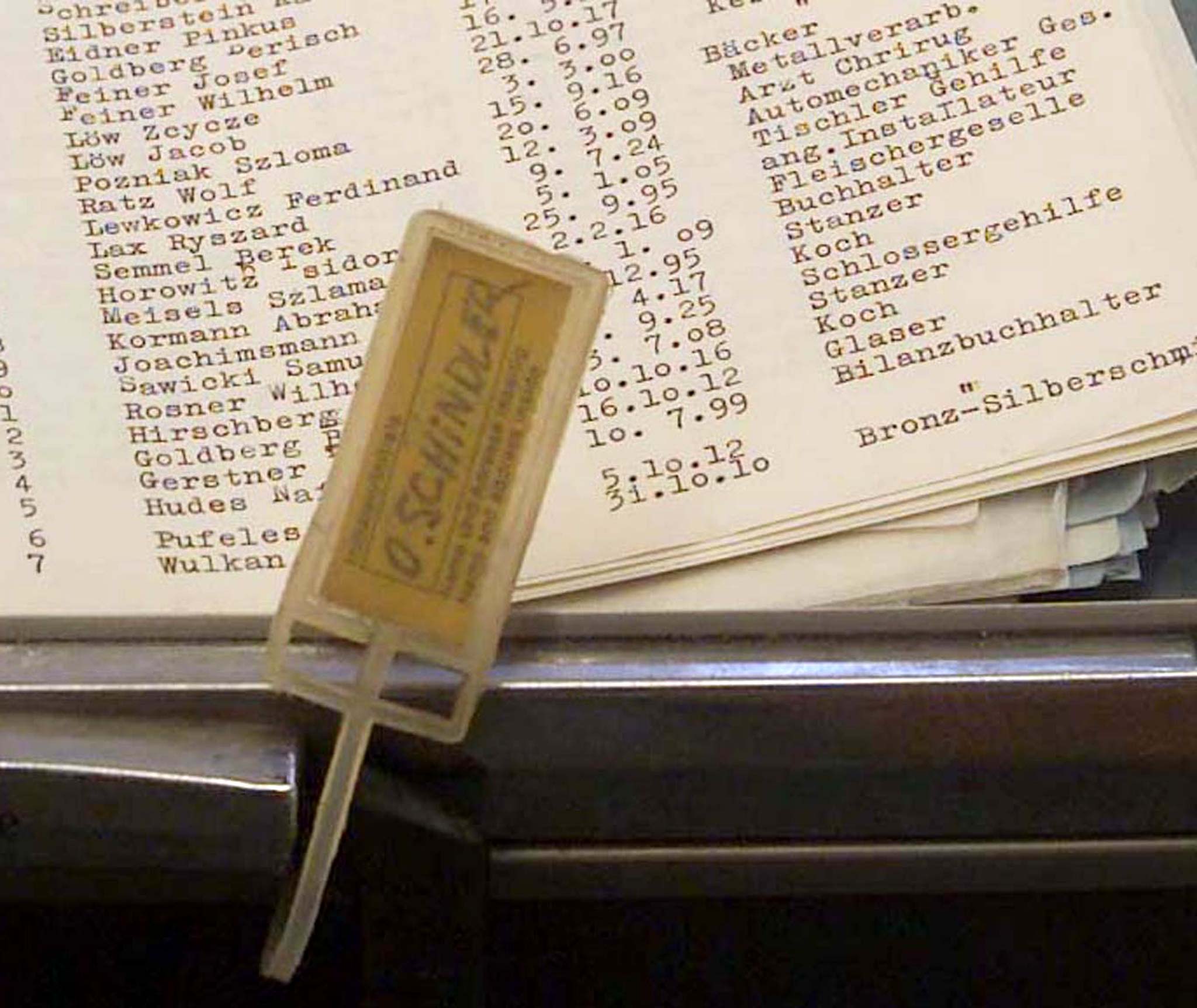 Picture shows the name tag "O. Schindler" on a suitcase with the original copy of a list of over 1,2..