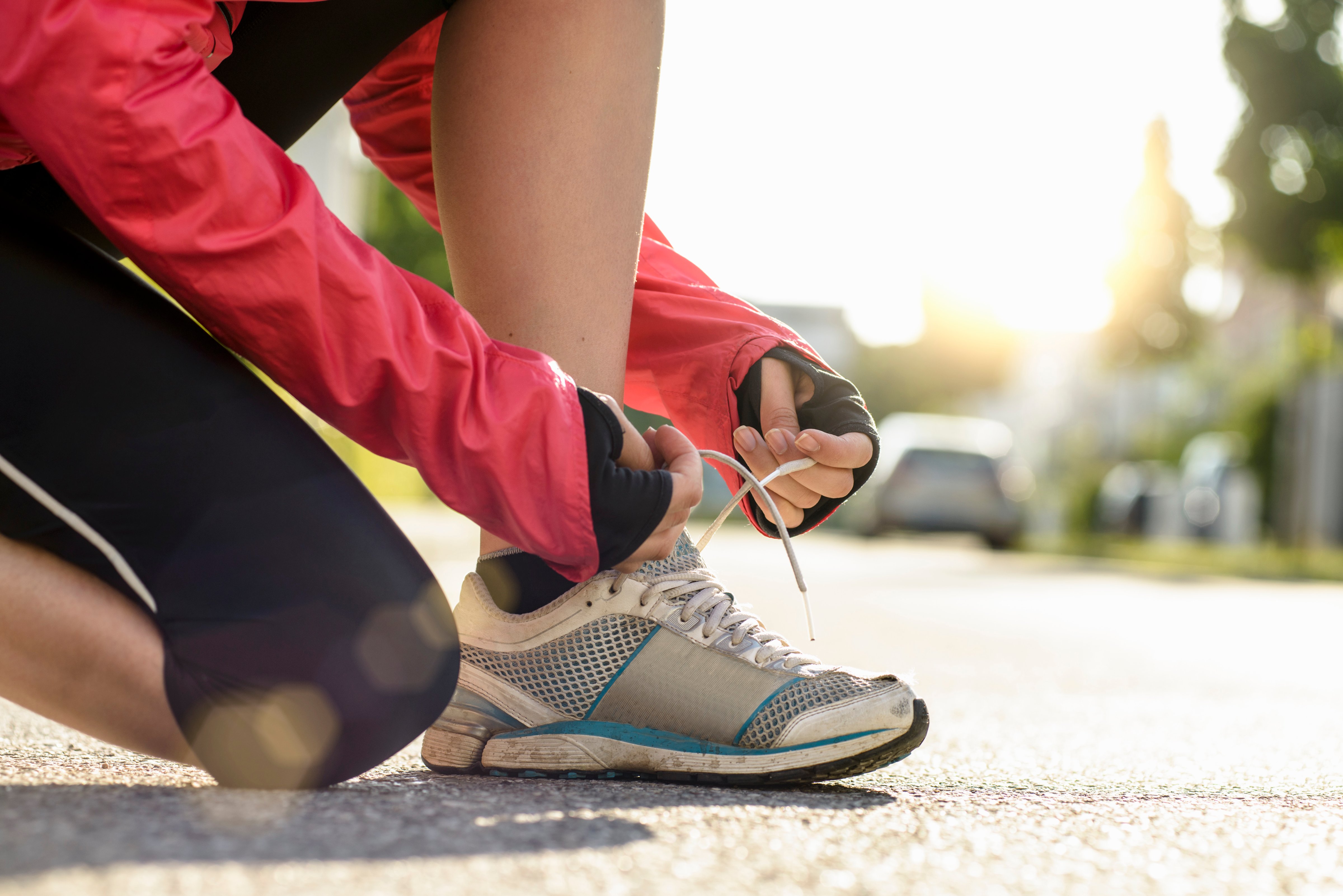 female runner tying shoe lace in a urban area
