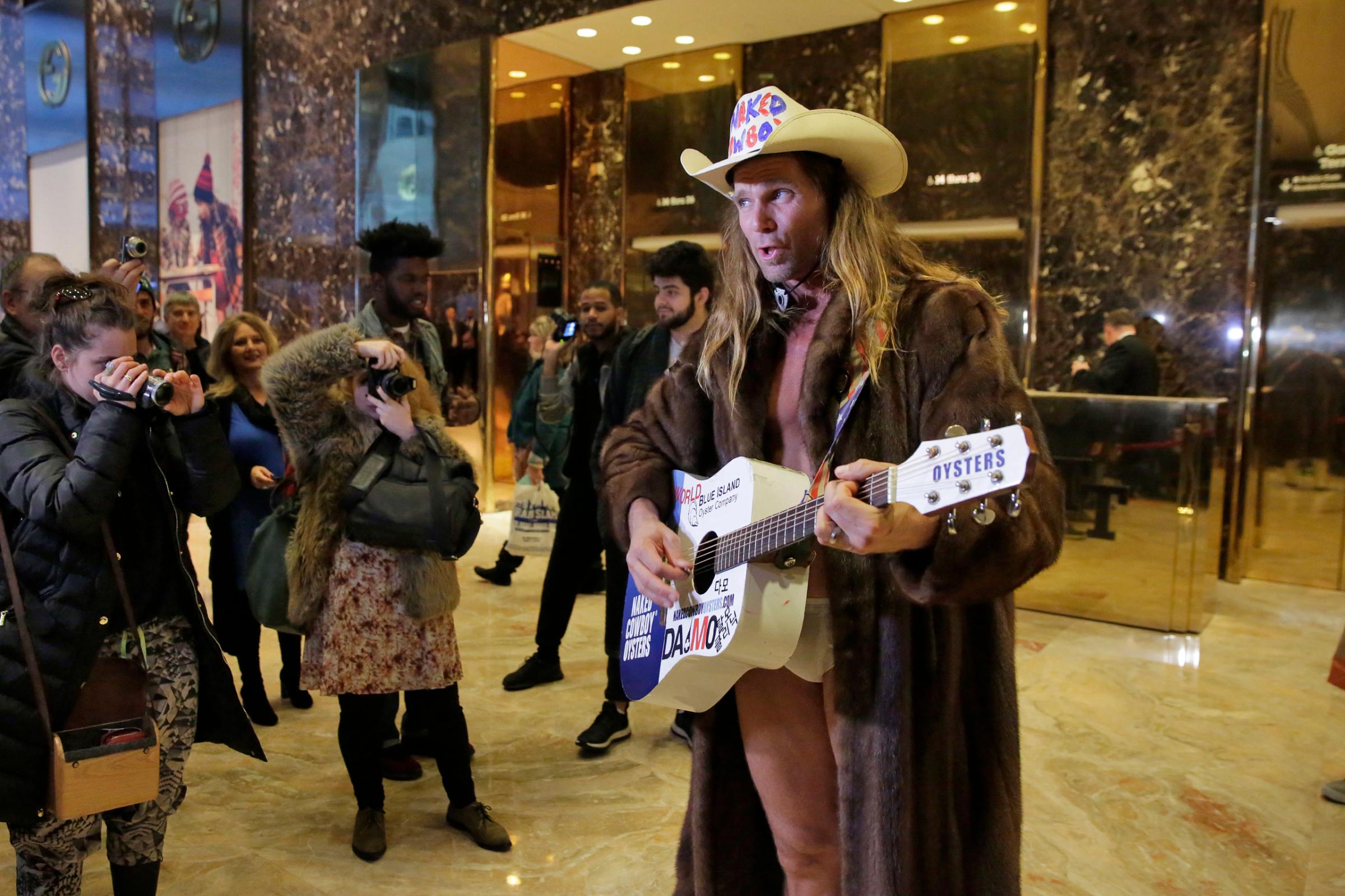 Robert Burck, who portrays the Naked Cowboy, performs a Trump-themed song in the lobby of Trump Tower in New York, on Nov. 18, 2016.