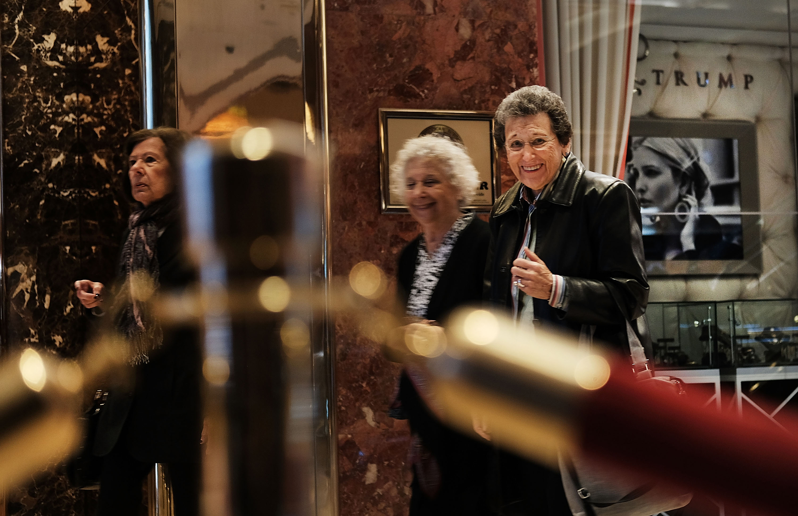 People walk through the lobby of Trump Tower as the media congregates in the lobby on Nov. 18, 2016.