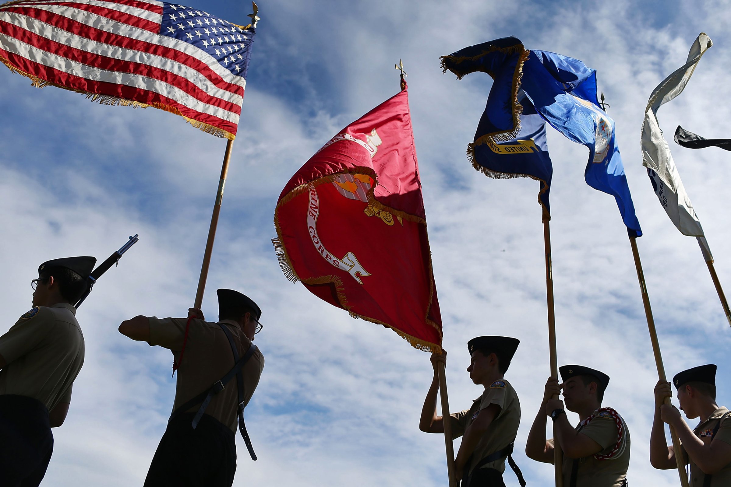 Members of the G. Holmes Braddock Senior High School NJROTC color guard carry their flags during a Veterans day ceremony in Miami Beach, Florida, on Nov. 11, 2015.