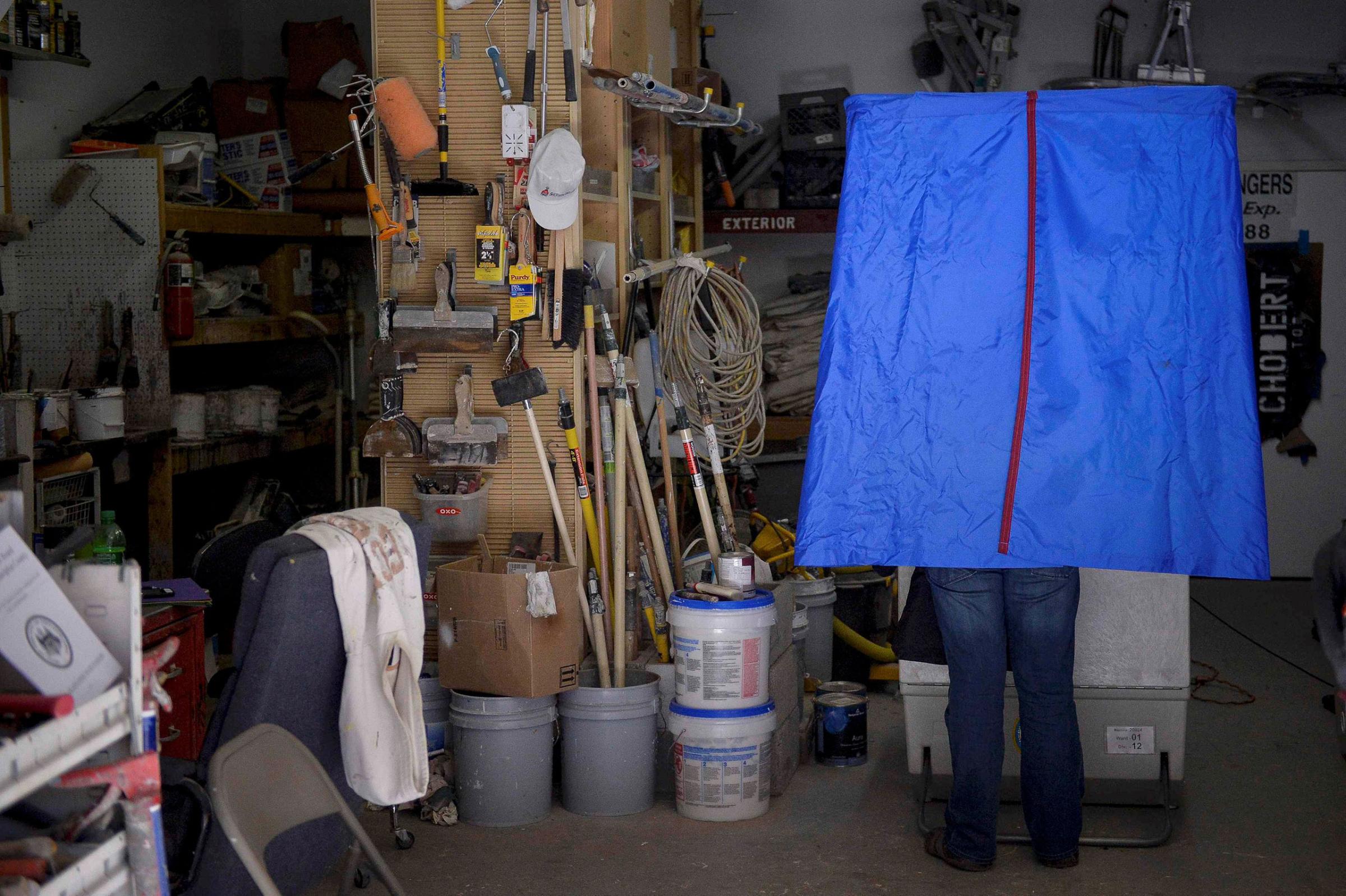 A voter casts his ballot inside the garage of Chobert Decorators during the U.S. presidential election in Philadelphia, Pennsylvania