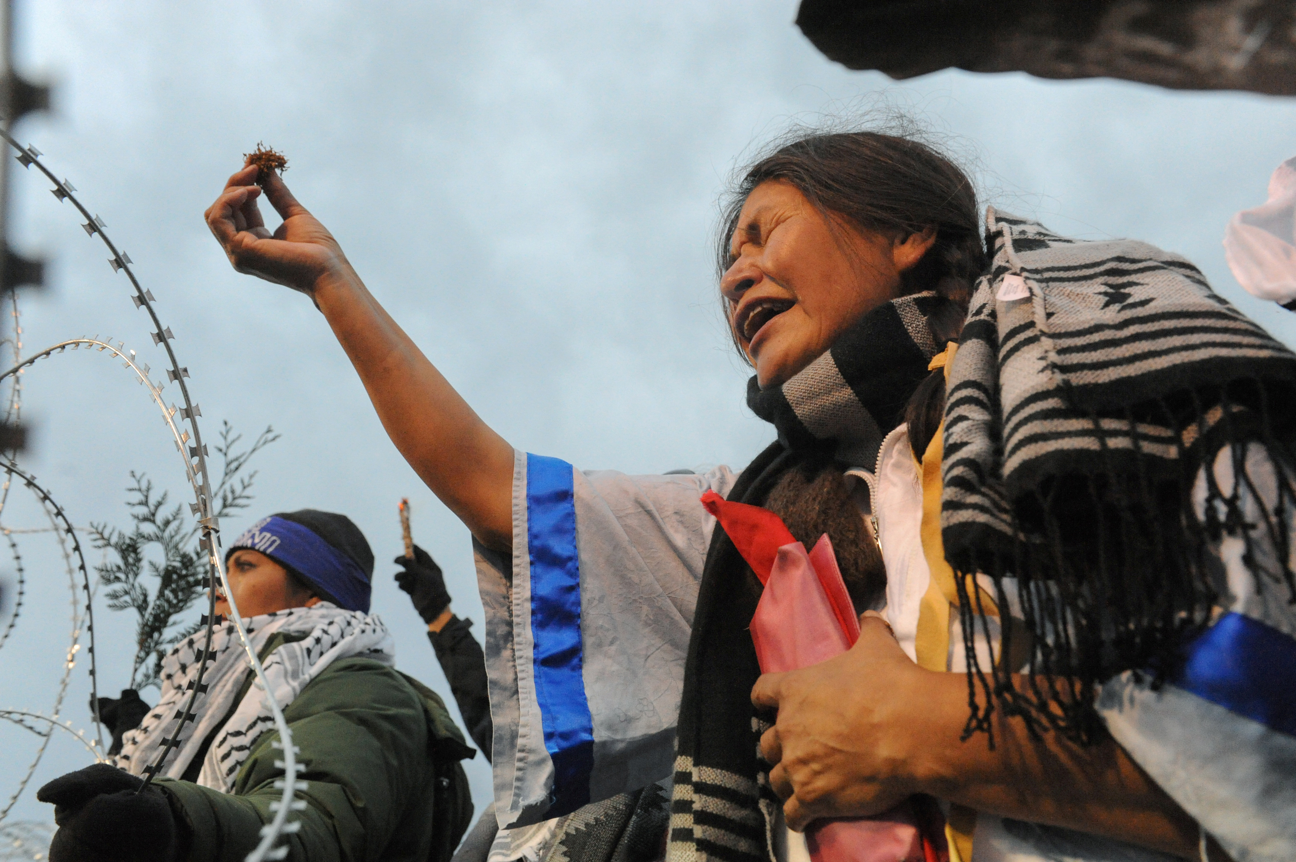 Cheryl Angel offers ceremonial tobacco on Backwater Bridge during a protest against plans to pass the Dakota Access pipeline near the Standing Rock Indian Reservation, near Cannon Ball, North Dakota, on Nov. 27, 2016. (Stephanie Keith—Reuters)