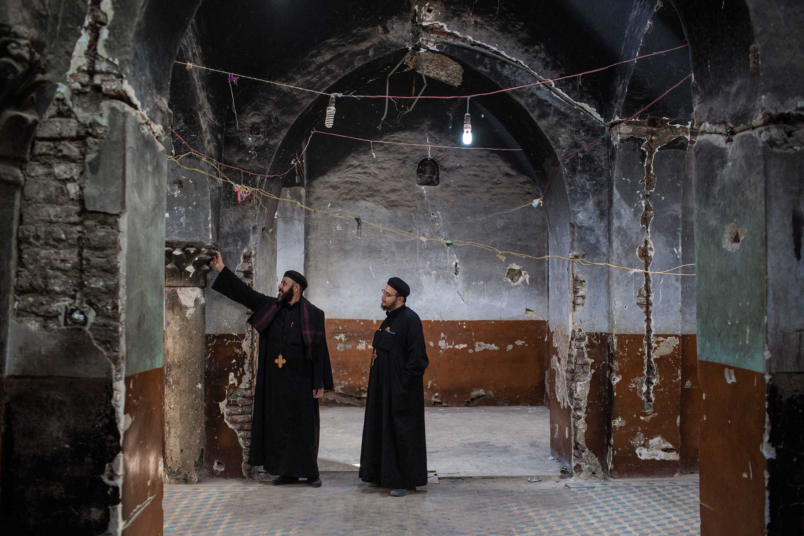 Silwanes Lotfy, the priest of the Anba Ebram church, looks at the destroyed side of the historical church in Delga village, Al Minya, Egypt, Feb. 29, 2016.