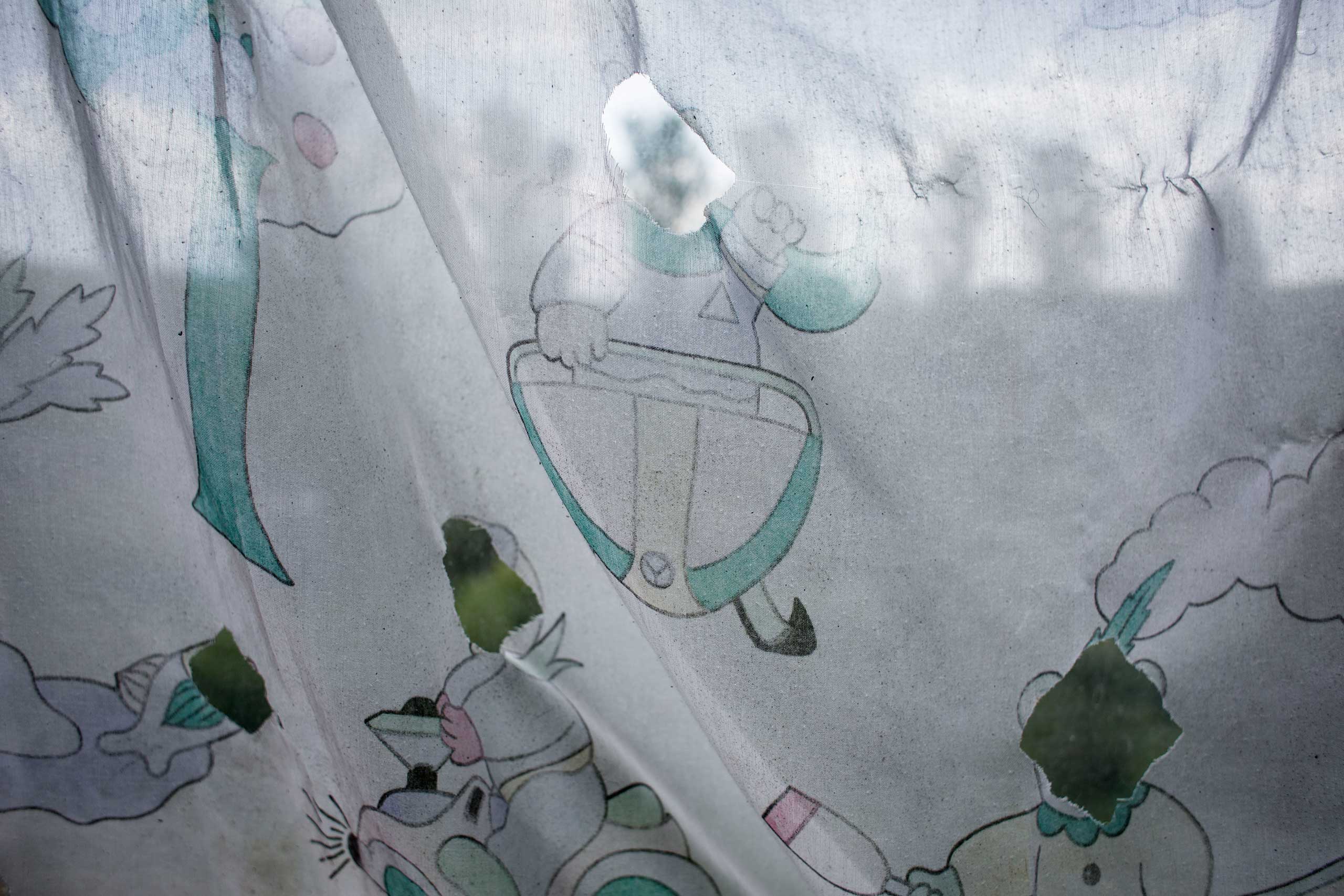 Curtains with cartoon characters hang in the dormitory room where Crimean Tatar families live. The Islamic tradition forbids portraying of the live creatures, animals that is why the faces of the cartoon animals were cut off.