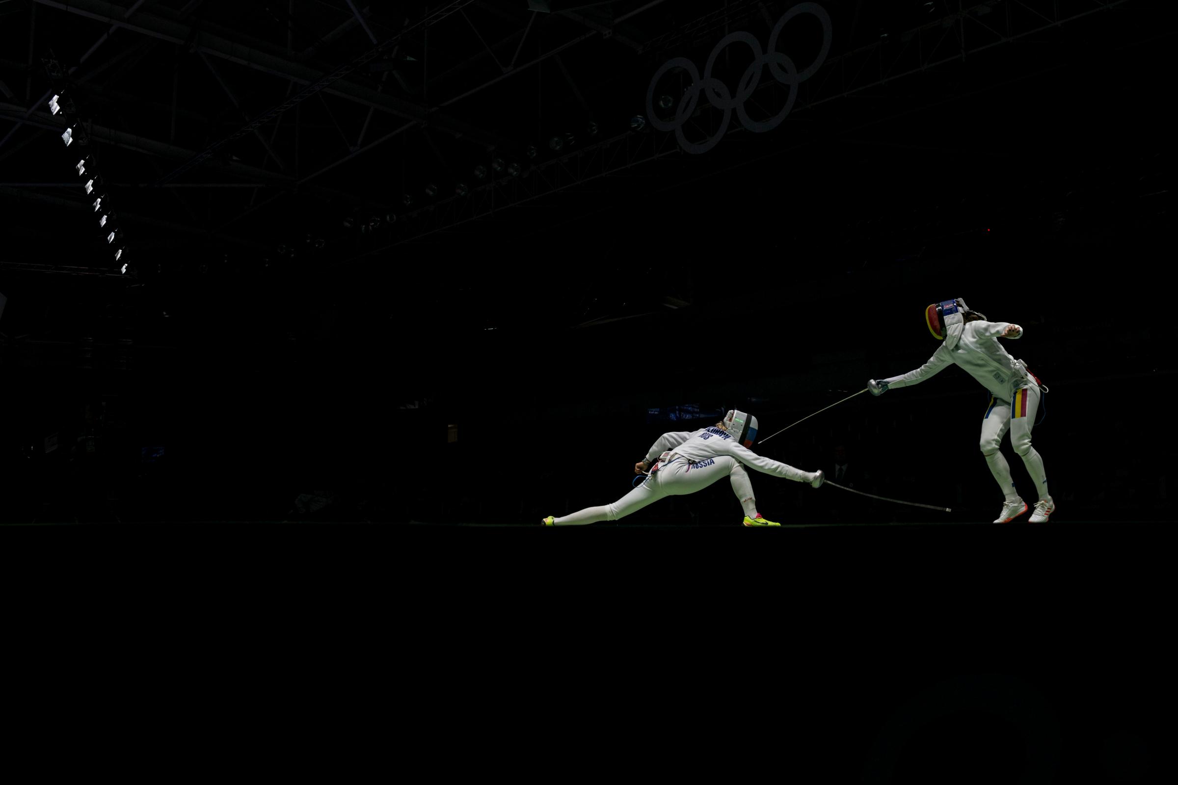 Violetta Kolobova of Russia, left, vies with Simona Pop of Romania in the women's epee team fencing semifinal at the Carioca Arena 3 during the 2016 Summer Olympics in Rio de Janeiro.