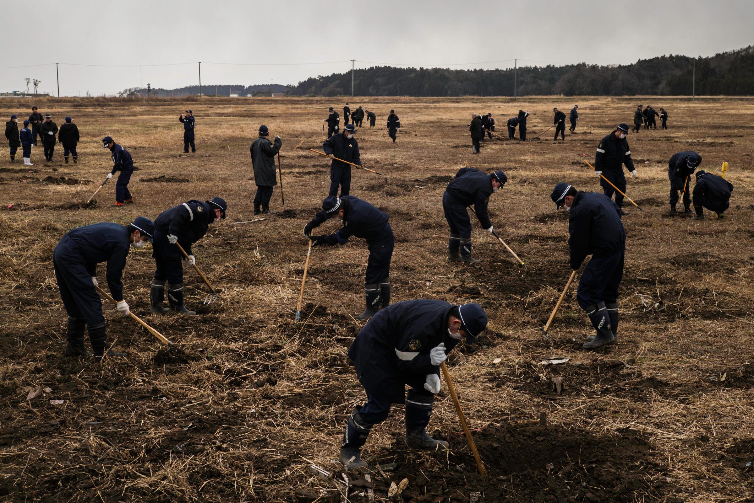 Police search inside the exclusion zone for residents who are still considered missing from the tsunami in Namie, Japan, on March 11, 2016. More than 2,500 people remain missing, according to government statistics.