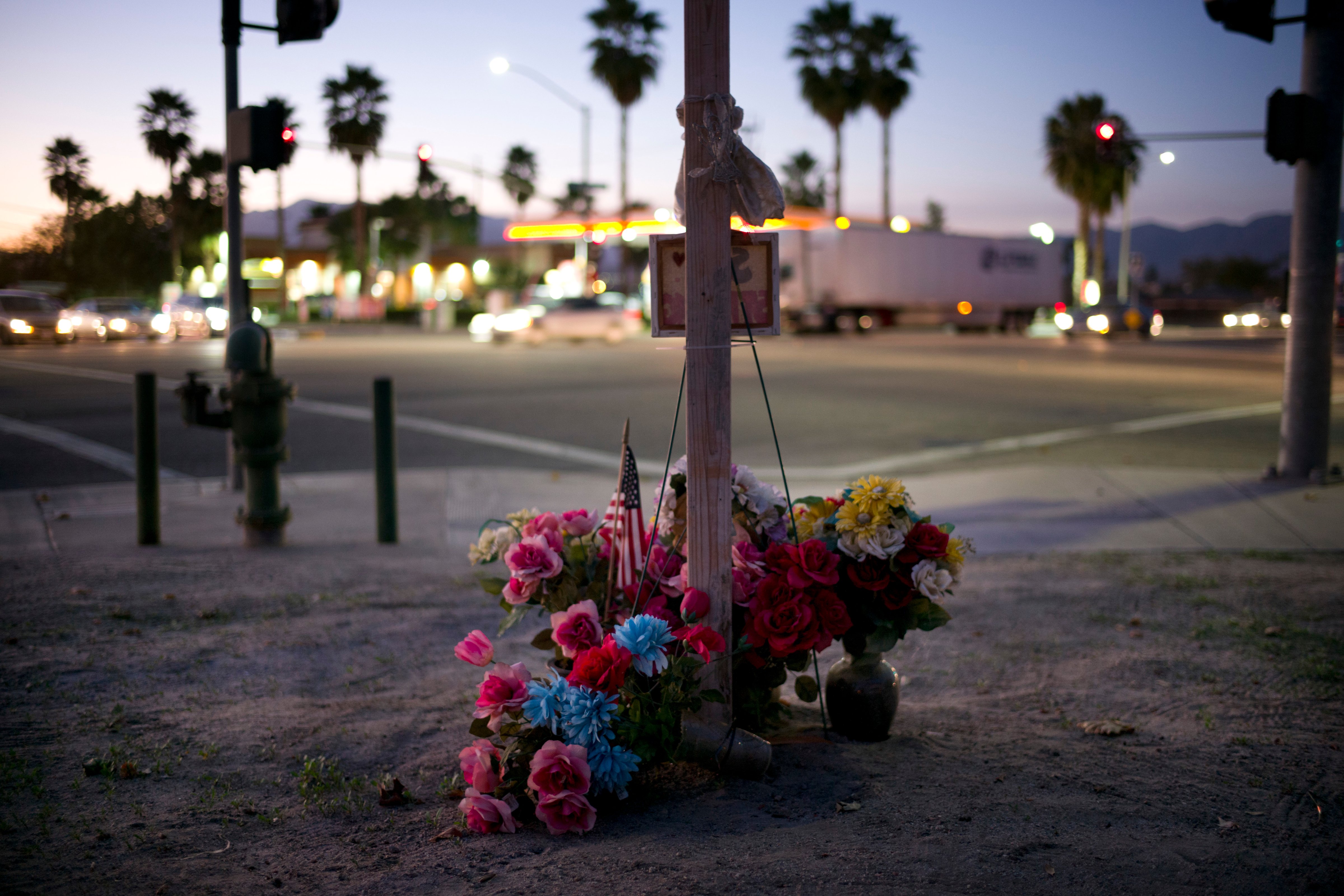 Artificial flowers are placed around a wood cross at a makeshift memorial site Nov. 15, 2016, near the Inland Regional Center, in San Bernardino, Calif., to honor the victims who were killed in the Dec. 2, 2015, terror attack at the center. (Jae C. Hong—AP)