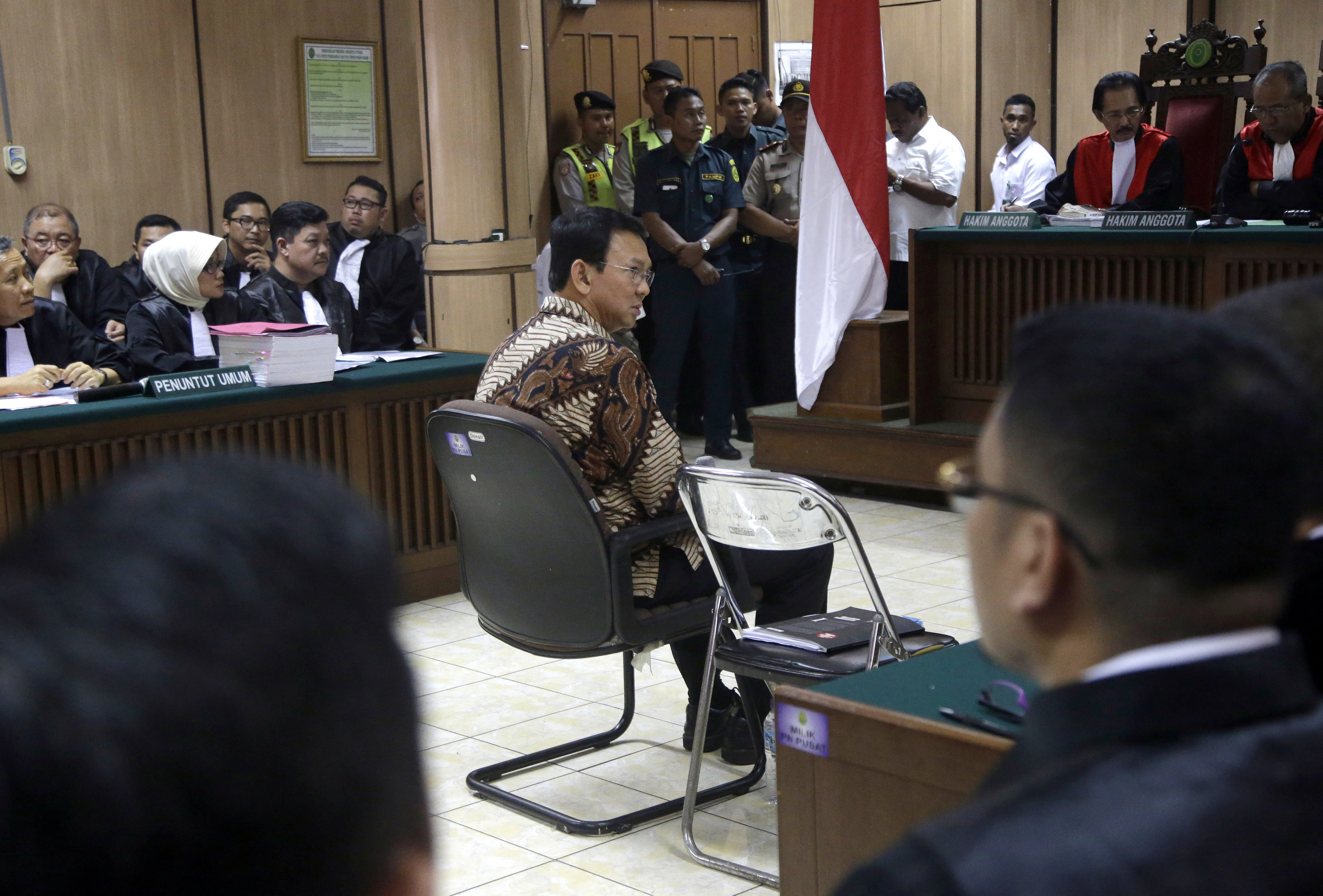 Jakarta Governor Basuki Tjahaja Purnama, popularly known as Ahok, center, sits on the defendant's chair at the start of his trial hearing at North Jakarta District Court in Jakarta on Dec. 13, 2016. Ahok is on trial on accusation of blasphemy following his remark about a passage in the Quran that could be interpreted as prohibiting Muslims from accepting non-Muslims as leaders (Tatan Syuflana—AP)