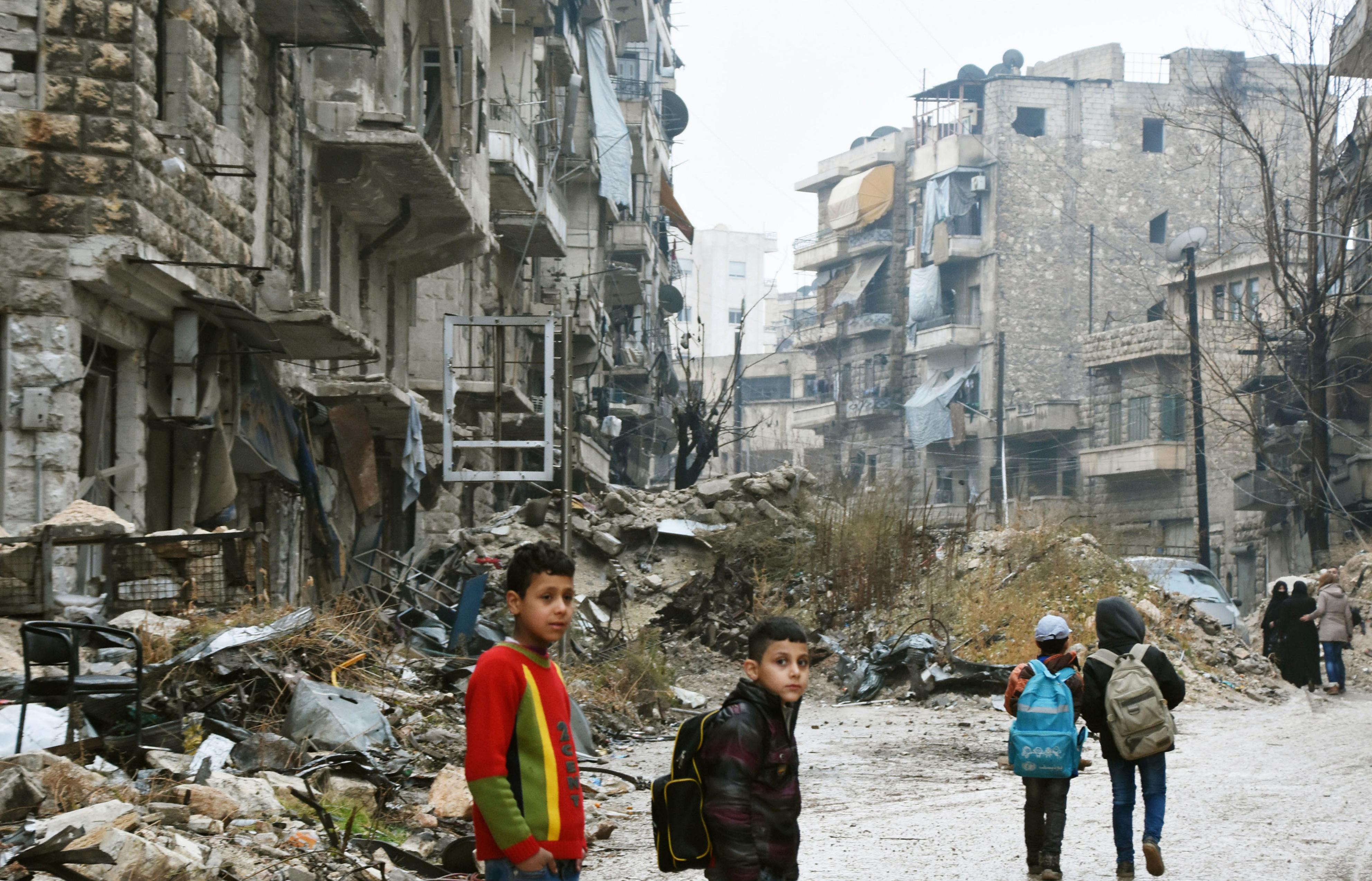 Children walk in a devastated area in the northern Syria city of Aleppo on Dec. 13, 2016, as troops loyal to the government of President Bashar al-Assad seemed poised to take complete control of the city that had been ruled by rebels. (Kyodo) (Kyodo—Kyodo)