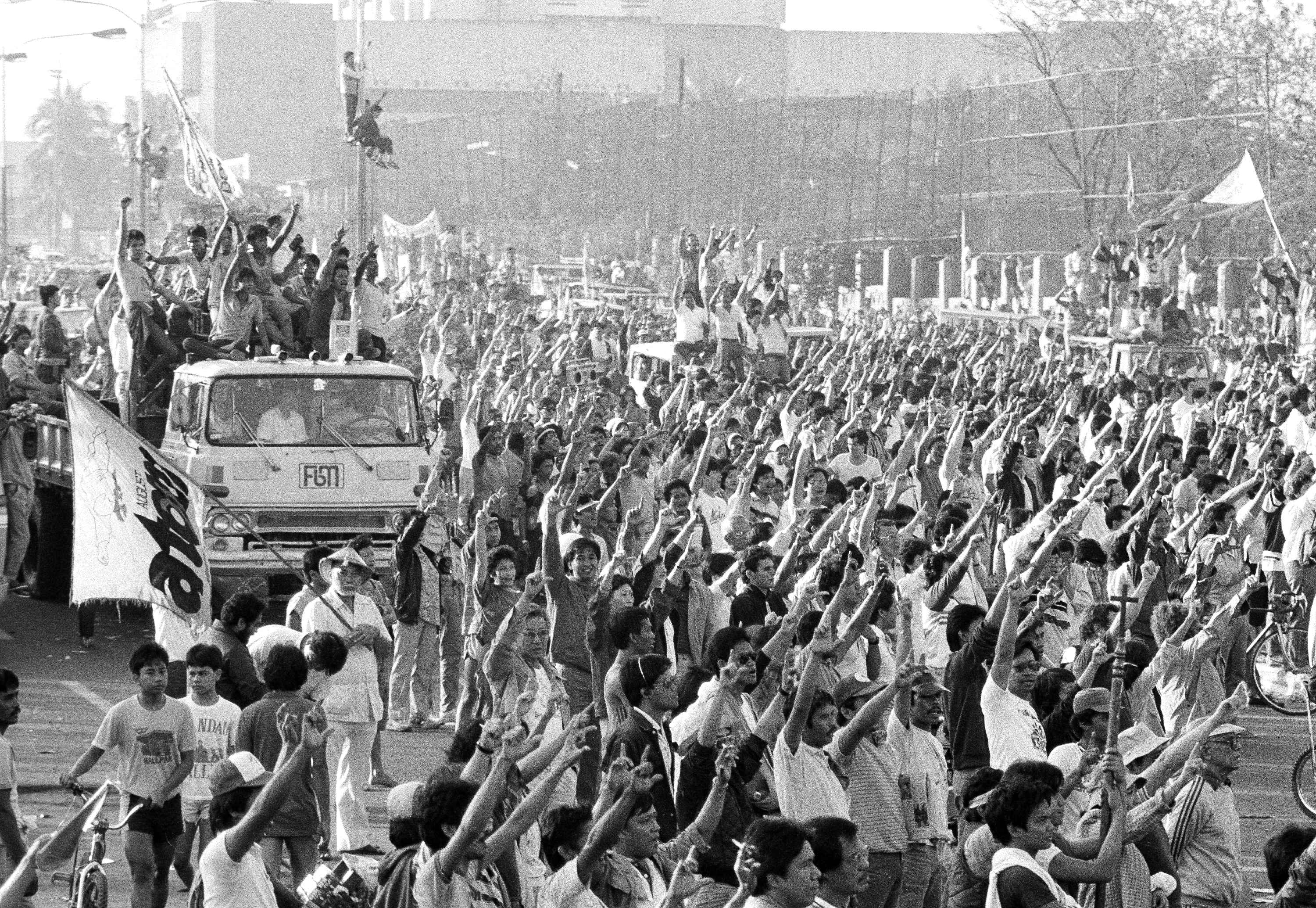 People power: a large crowd outside Camp Crame in Manila on Feb. 24, 1986, cheers at a radio announcement that President Ferdinand Marcos has fled the country (Sadayuki Mikami—AP)