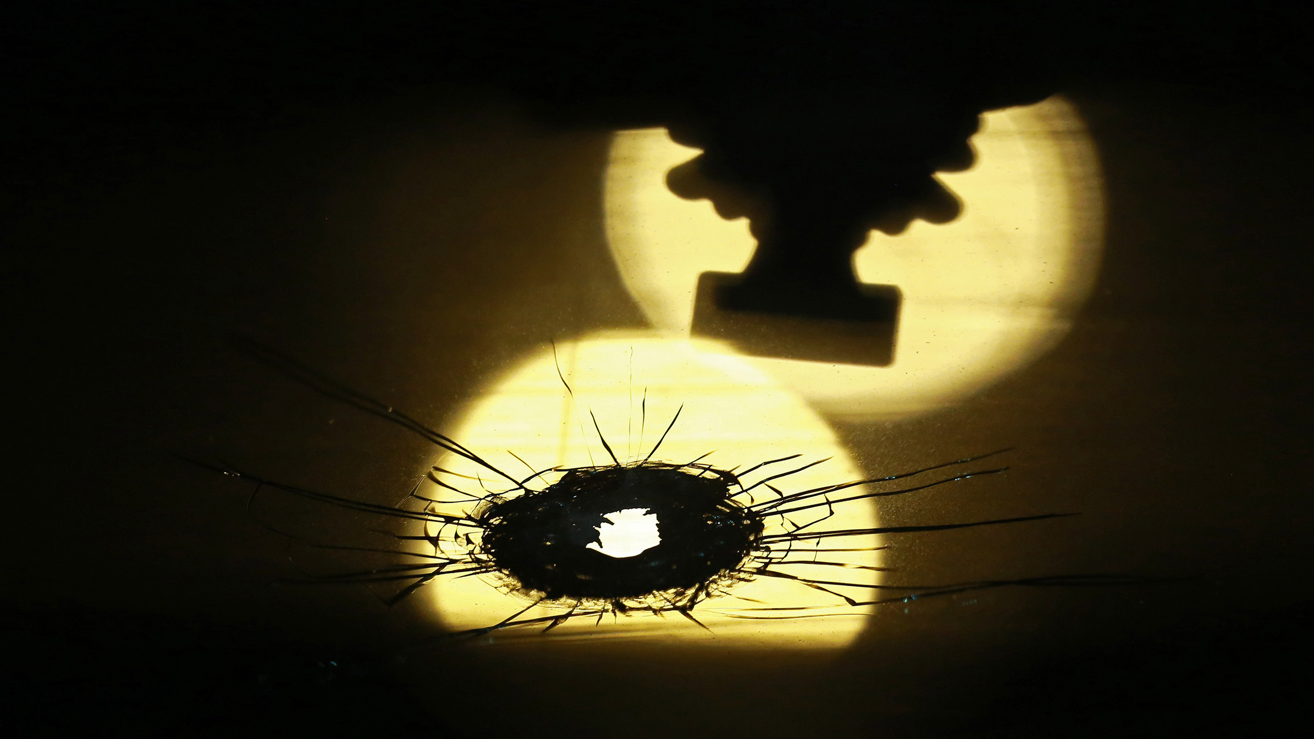 A bullet hole in a windshield is silhouetted against a street light at a crime scene in the first block of West 110th Place in Chicago, Ill., on Oct. 22, 2016. A 30-year-old man was grazed by a bullet and refused medical attention. (John J. Kim/Chicago Tribune/TNS via Getty Images) (John J. Kim—Chicago Tribune/TNS/Getty Images)