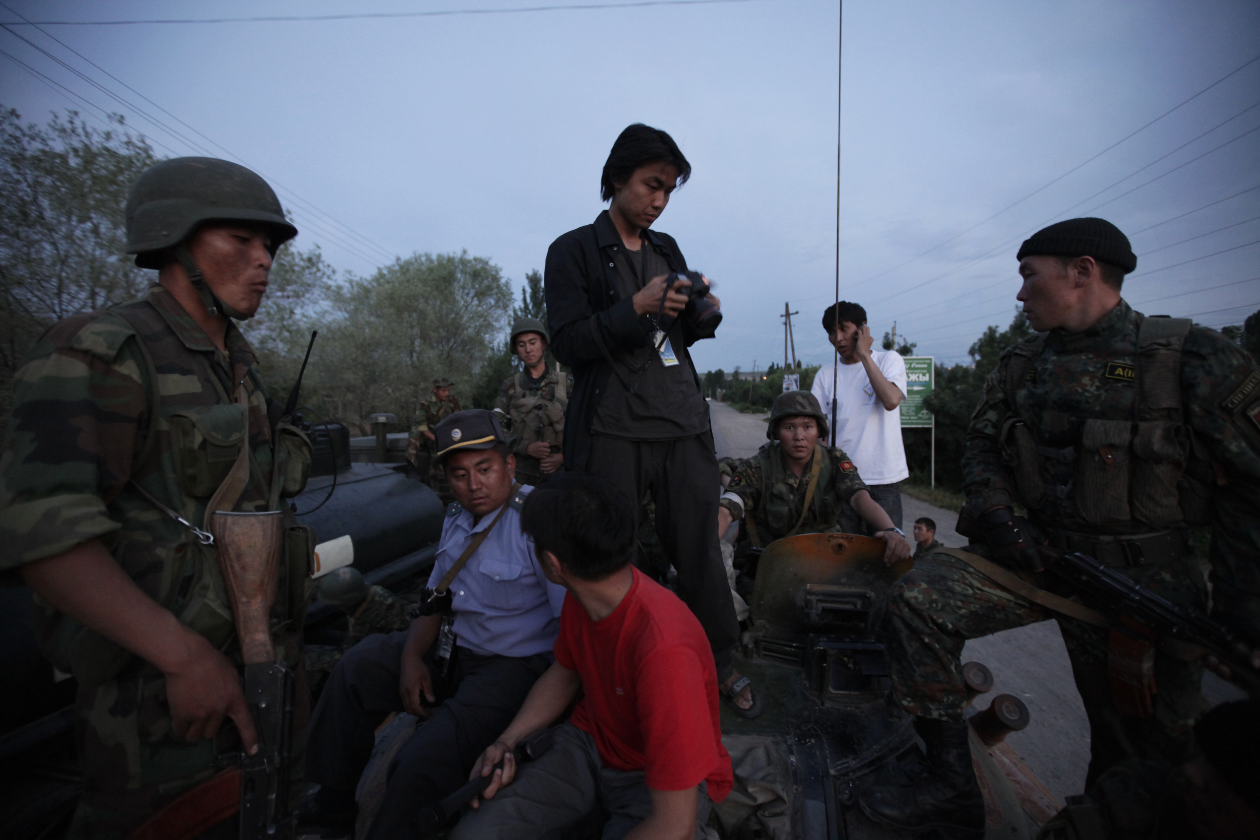 Ed Ou stands atop a Kyrgyz military tank while covering a flareup of violence after ethnic Kyrgyz mobs rampaged through minority Uzbek enclaves, burning homes and businesses in Osh, Kyrgyzstan. (Marina Gorobevskaya)