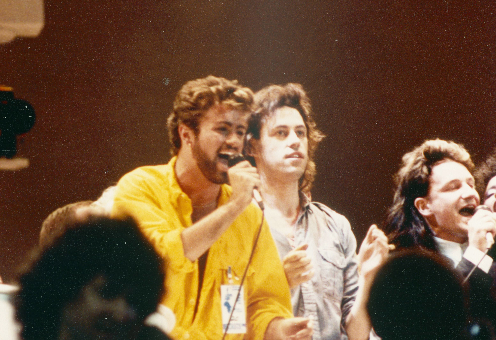George Michael performs with Bob Geldof and Bono as part of Live Aid in London, on July 13, 1985.