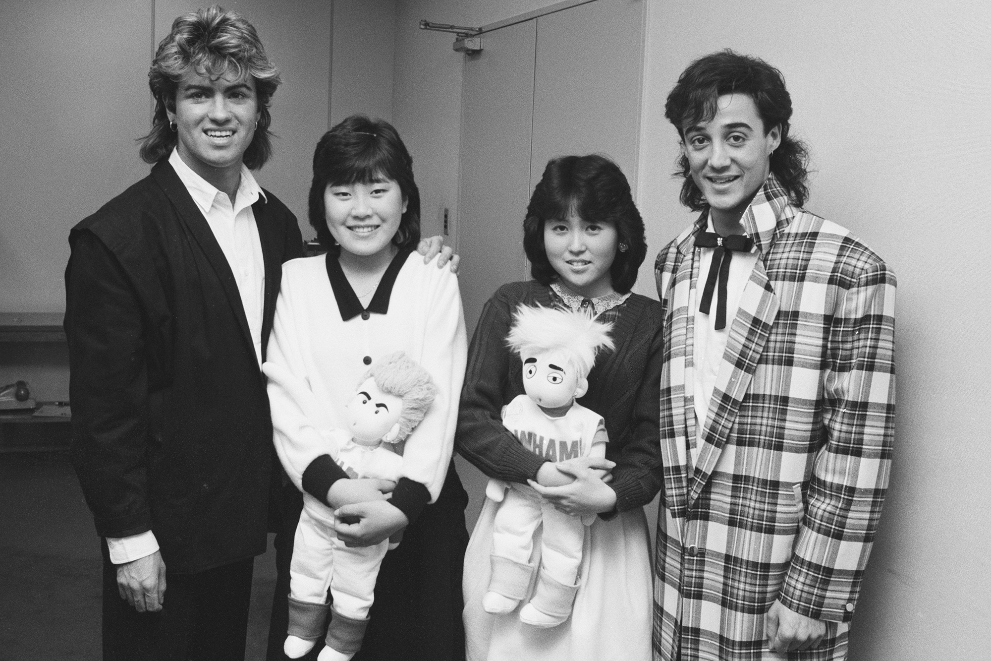 George Michael and Andrew Ridgeley of Wham!, with two fans during their 1985 world tour, in Japan, Jan. 1985.