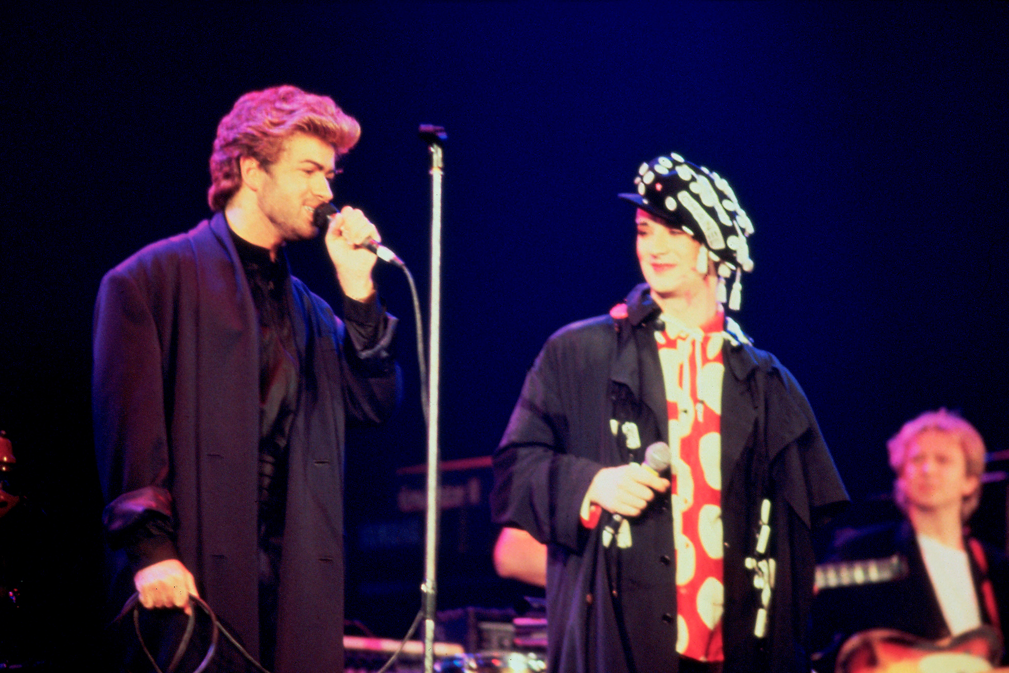 George Michael performs with Boy George and The Police's Andy Summers at an AIDS awareness concert in London, April 1987.
