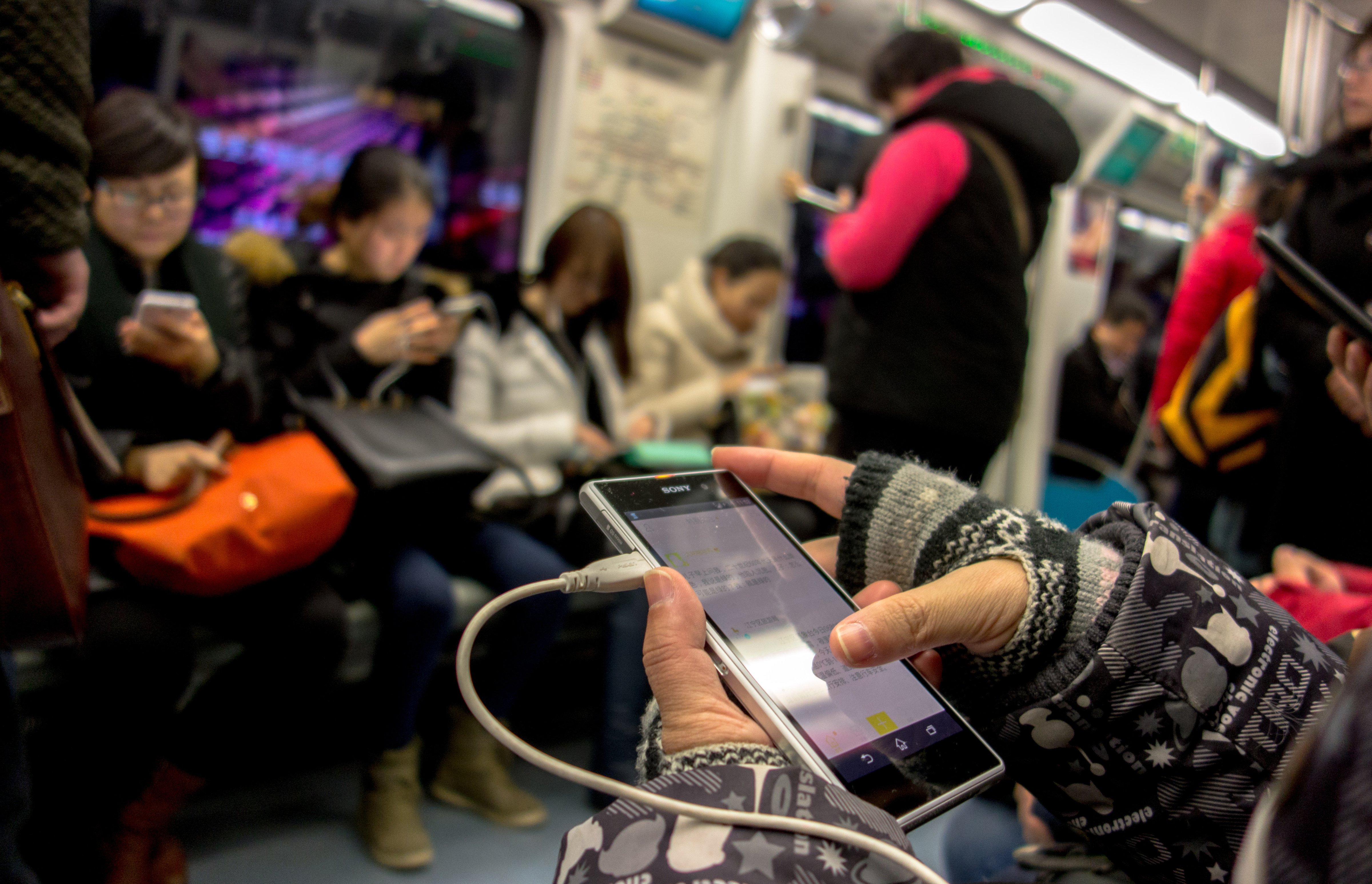 Passengers read news or watch videos on their smart phones in the subway on Jan. 28, 2015. (Zhang Peng—LightRocket/Getty Images)
