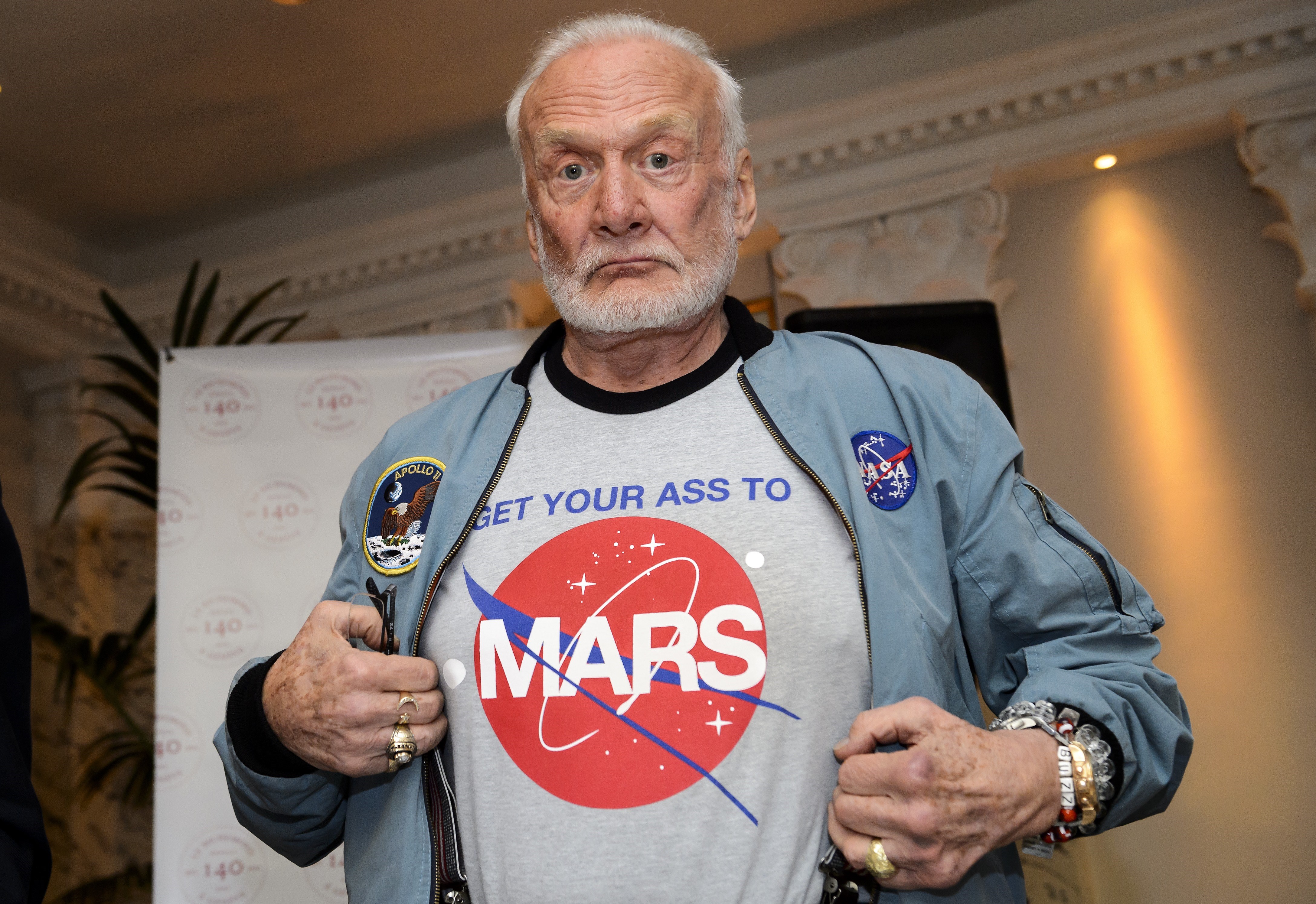 Former NASA astronaut Buzz Aldrin shows the T-shirt he wears promoting Mars exploration on Nov. 12, 2015, in Geneva (Fabrice Coffrini—AFP/Getty Images)
