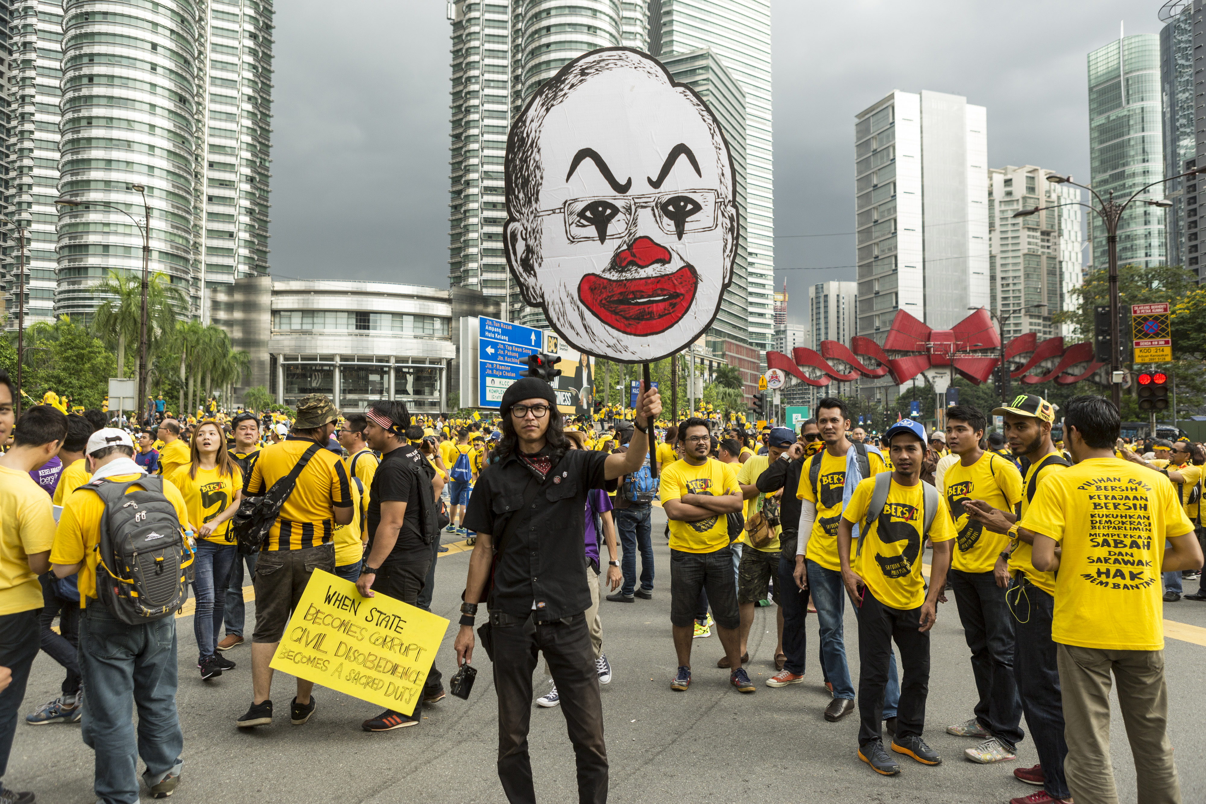 A protester holds up a placard near the Petronas Twin Towers during the Coalition for Clean and Fair Elections rally, also known as Bersih, in Kuala Lumpur on Nov. 19, 2016 (Charles Pertwee—Bloomberg/Getty Images)