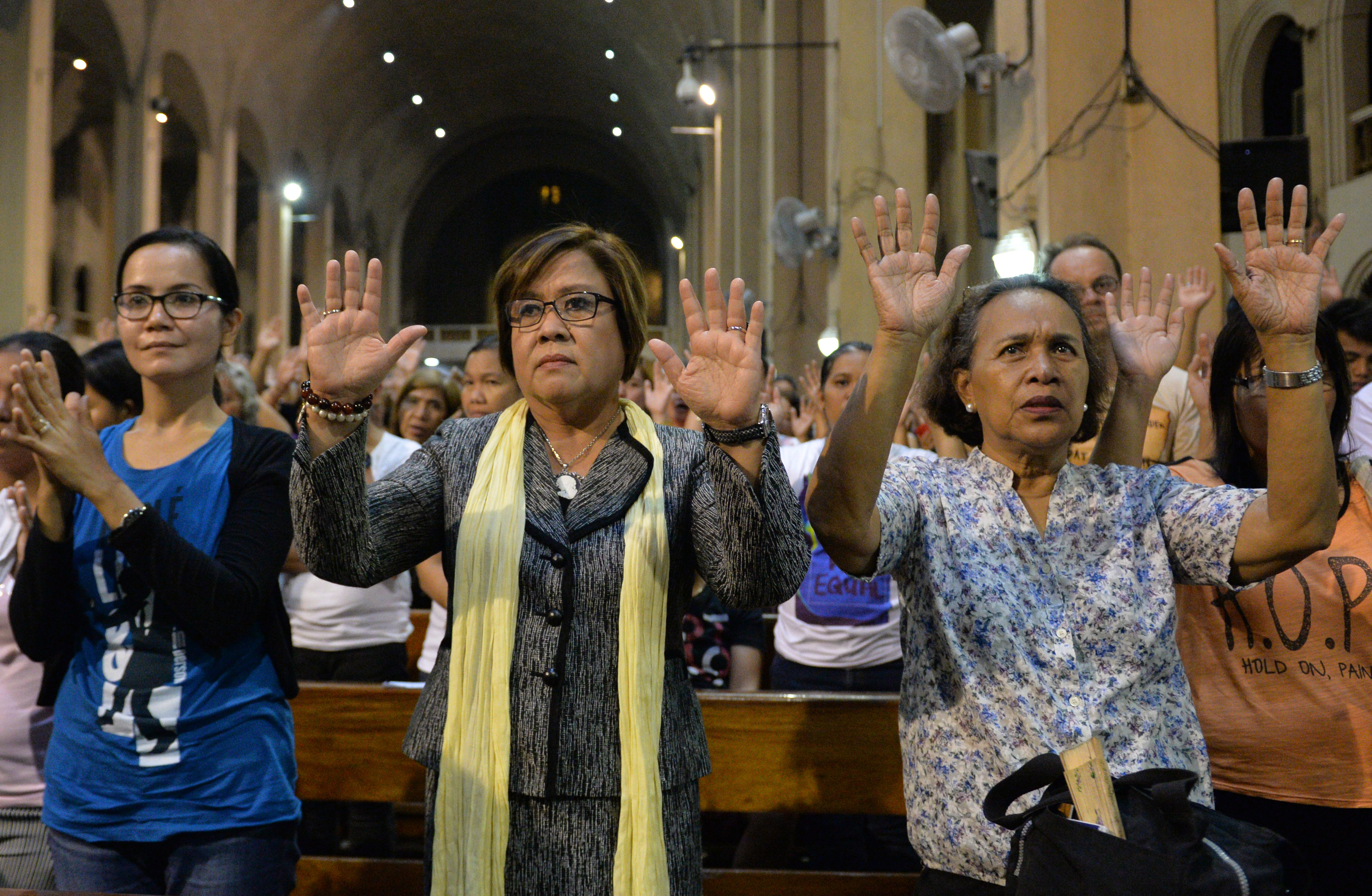 Philippine Senator Leila de Lima, center, gestures along with Catholic faithful, as they offer prayers during a mass for all the victims of the Philippine drug war, at a church in Manila on Nov. 23, 2016 (Ted Aljibe—AFP/Getty Images)