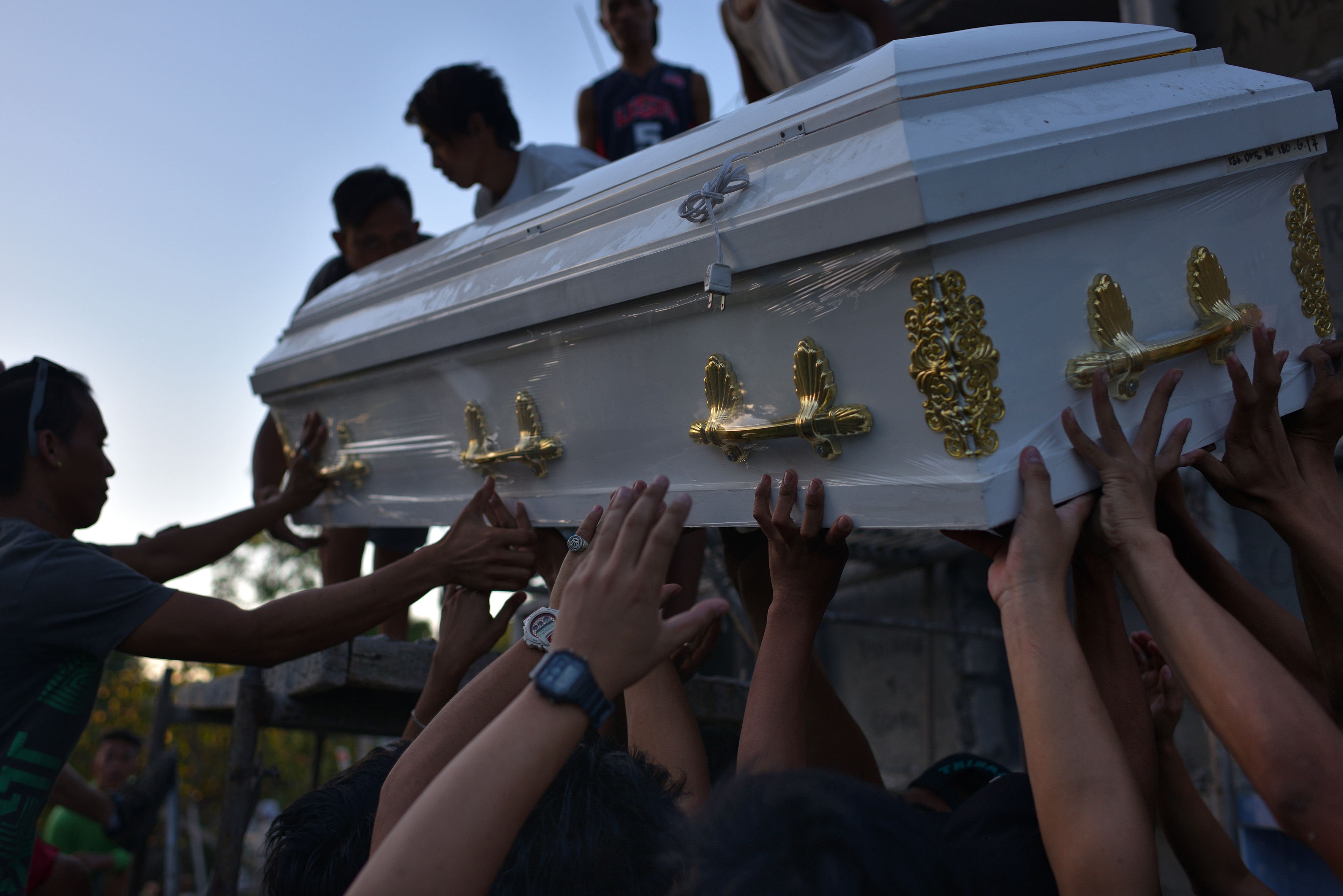 Friends and family carry the coffin of Jerico Camitan in a public cemetery on Nov. 13, 2016, in the Philippine city of Caloocan. Camitan, 21, and his partner Erica Fernandez, 17, were killed by two gunmen. A placard saying that they were drug pushers was placed near their bodies, although a drug test during autopsy cleared them of any drug use. Police said that they are not on any drug watch-list. (Jes Aznar—Getty Images)