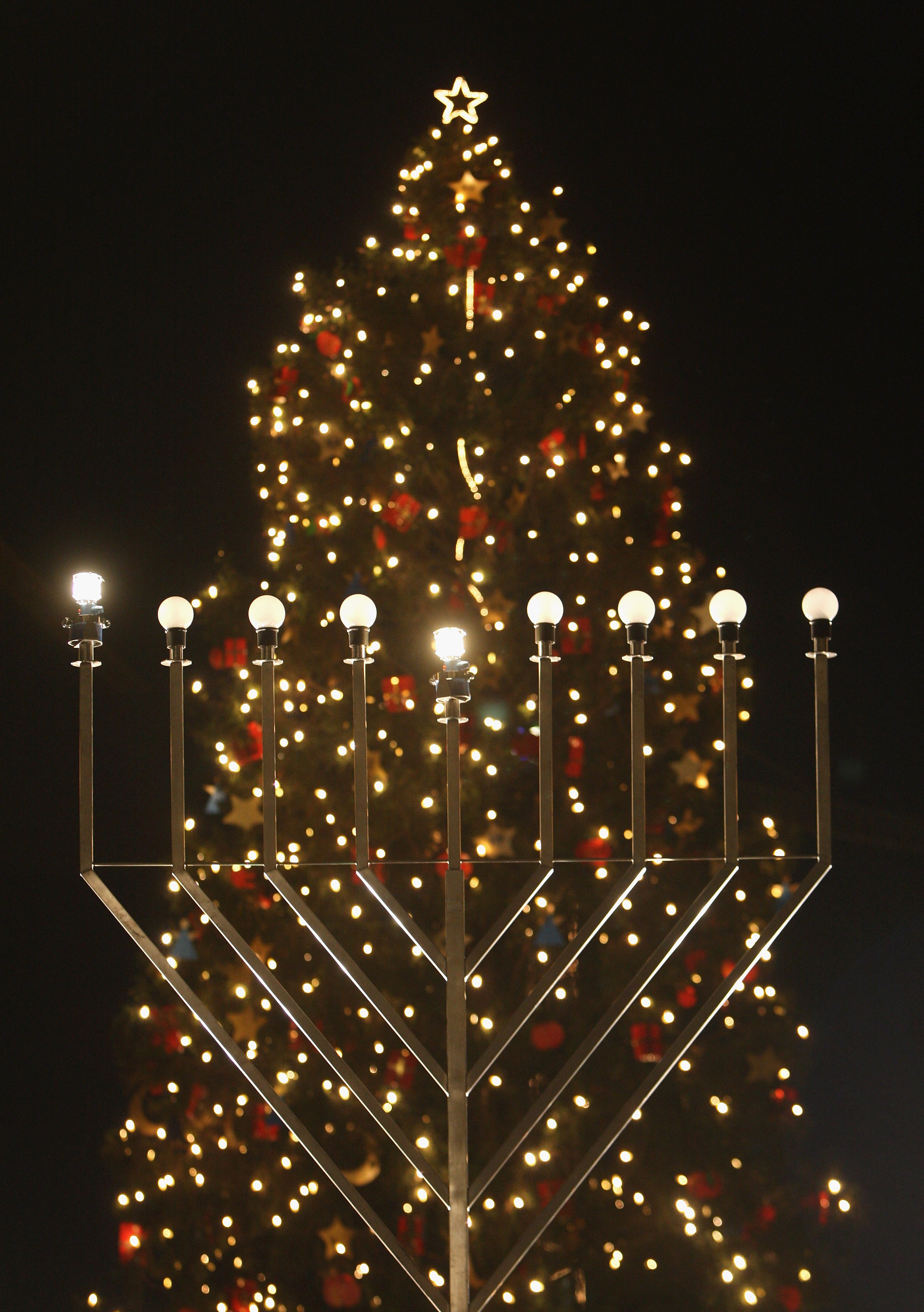 A giant, gas-lit menorah stands in front of a Christmas tree shortly after members of the local Jewish community lit the menorah on the night before the first day of Hannukah on Dec. 4, 2007 in Berlin, Germany. (Sean Gallup—Getty Images)
