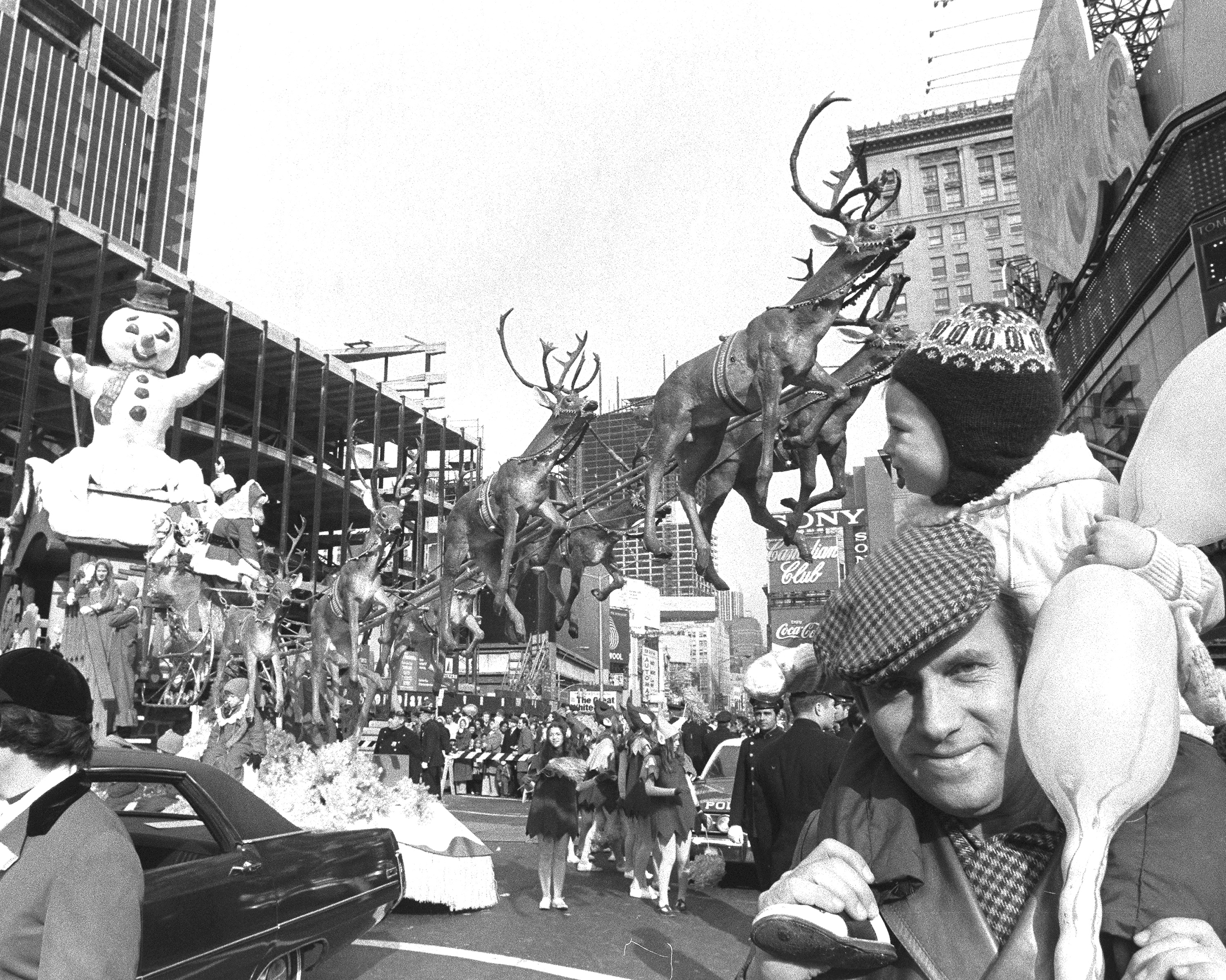 New York City. November 26th, 1970. A snowman, eight tiny reindeer and a few thousand other accompany Santa Claus as he sails through Macy's Thanksgiving Day parade in Times Square.