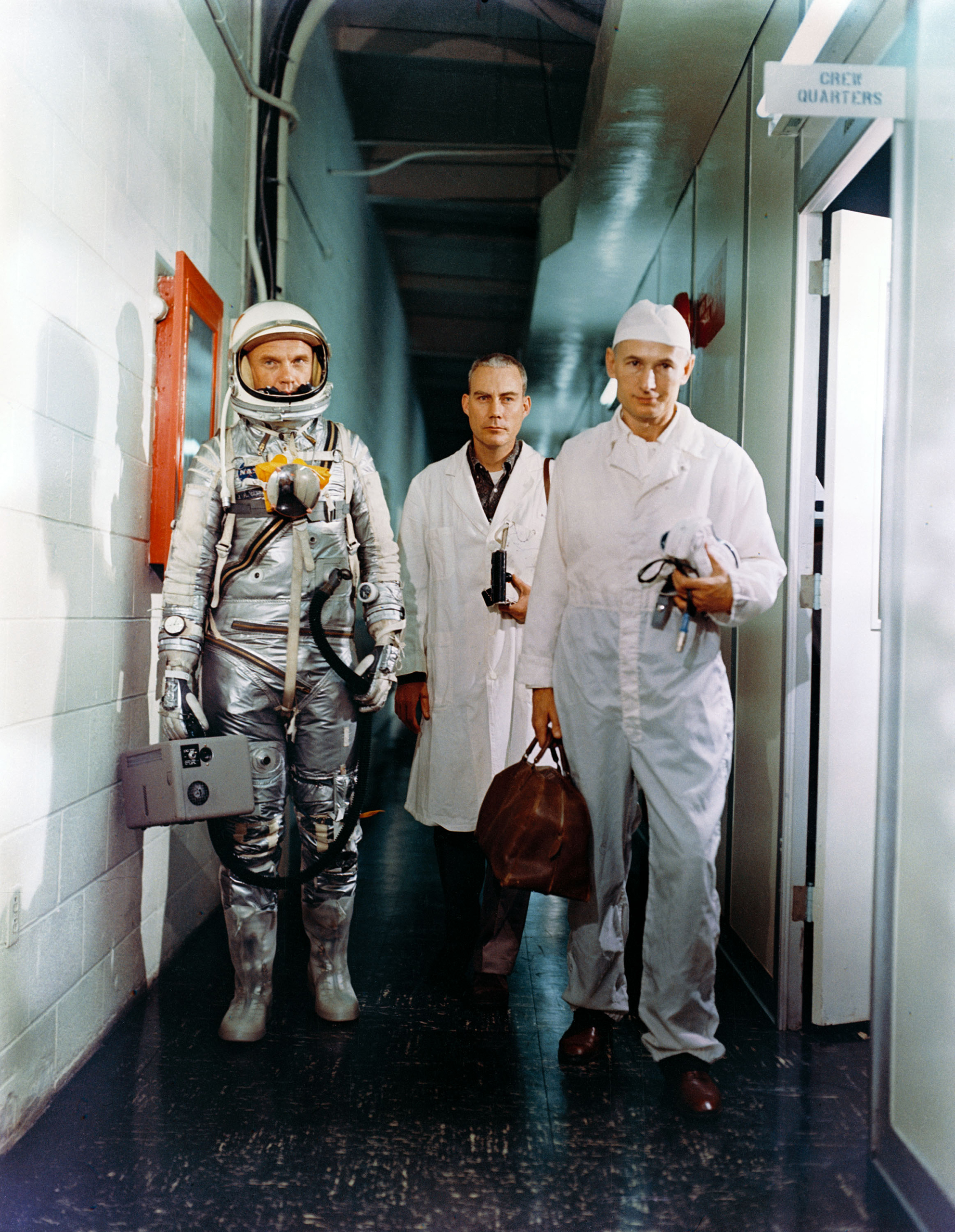 Suited Up Glenn's walk into history began in an unprepossessing hallway as he left the crew quarters on the morning of his Feb. 20, 1962, launch in the company of a flight surgeon and an equipment specialist.